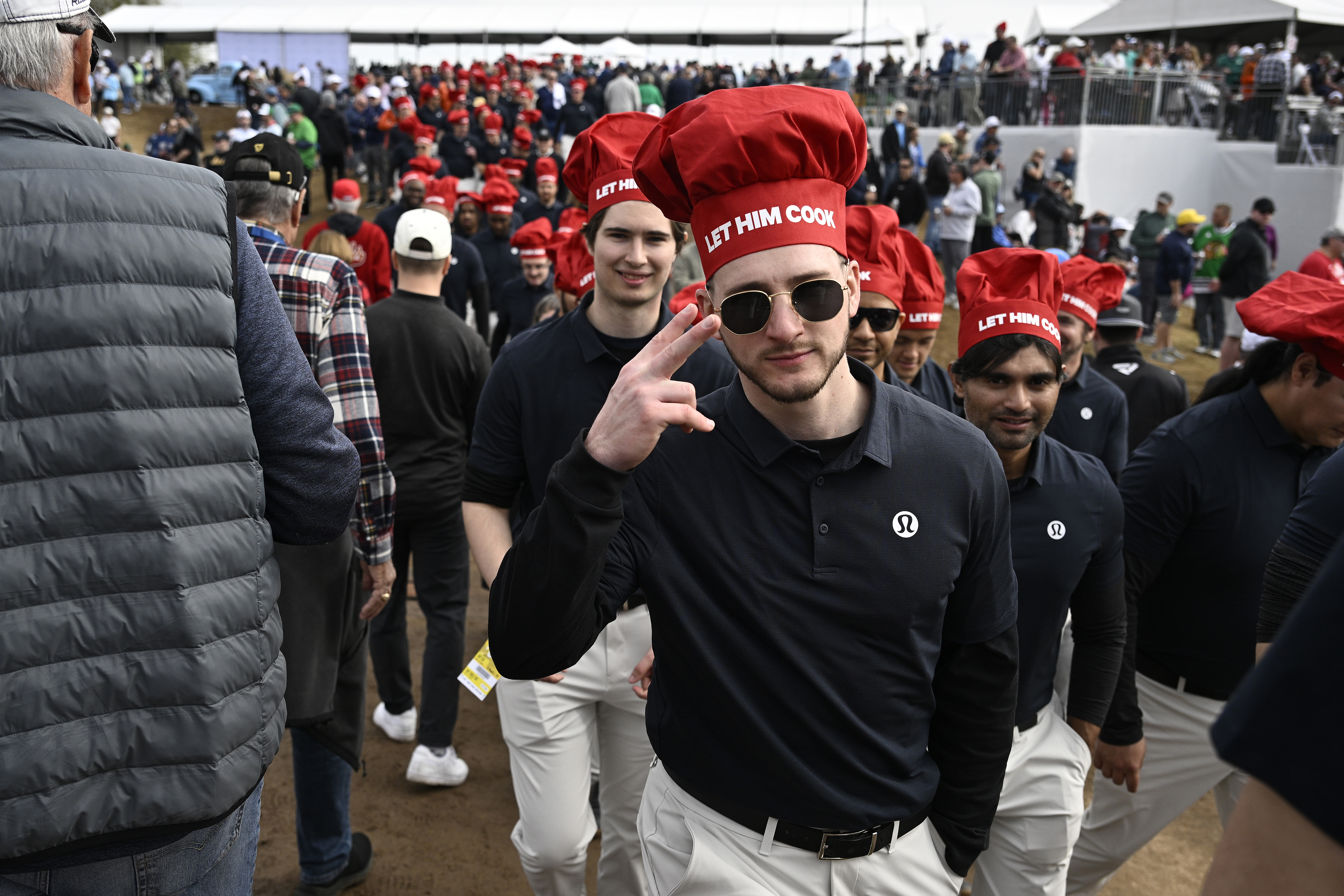 Fans of Aussie Min Woo Lee wear "Let Him Cook" chefs' hats during his second round at the 2024 Phoenix Open.