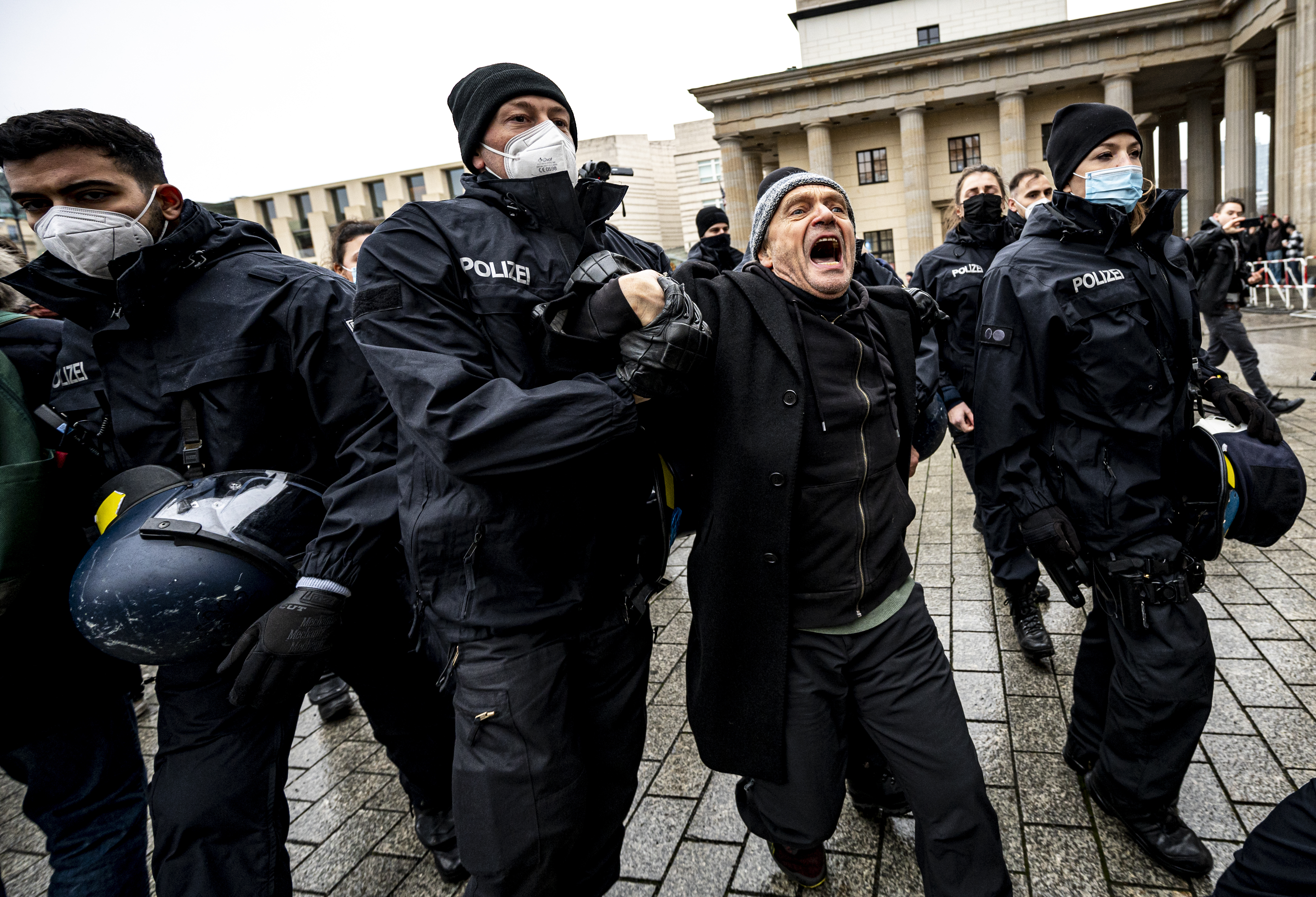 The Berlin police takes away a participant of the forbidden demonstration of opponents of Corona rules in Berlin, Germany, Saturday, Dec. 18, 2021