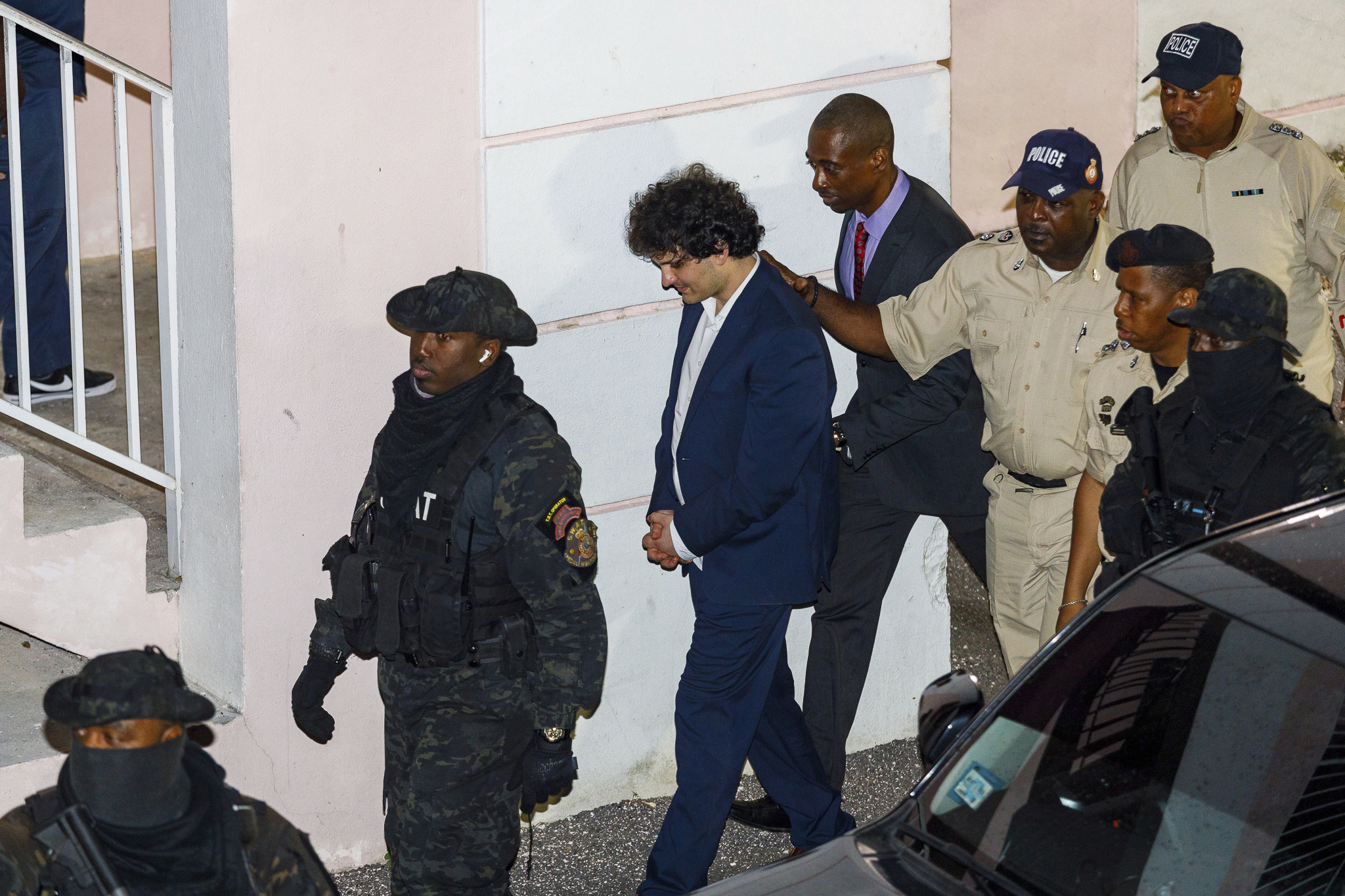 Samuel Bankman-Fried, centro, es escoltado fuera del edificio del Tribunal de Primera Instancia el día después de su arresto en Nassau, Bahamas, el martes 13 de diciembre de 2022. 