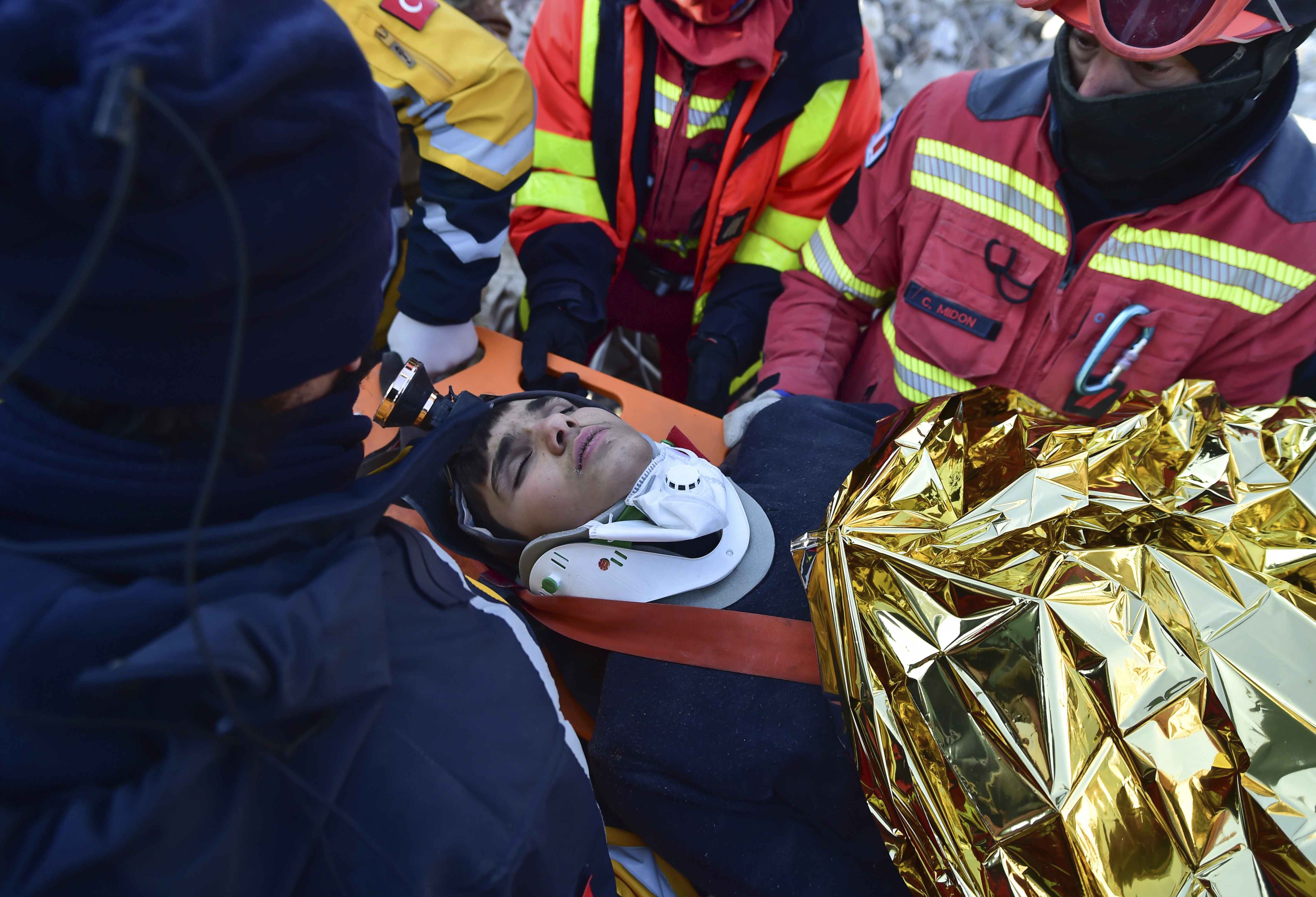 Rescue workers pull out Muhammed Enes Yeninar from the debris of a collapsed building in Kahramanmaras, southern Turkey, Tuesday, Feb. 14, 2023. 