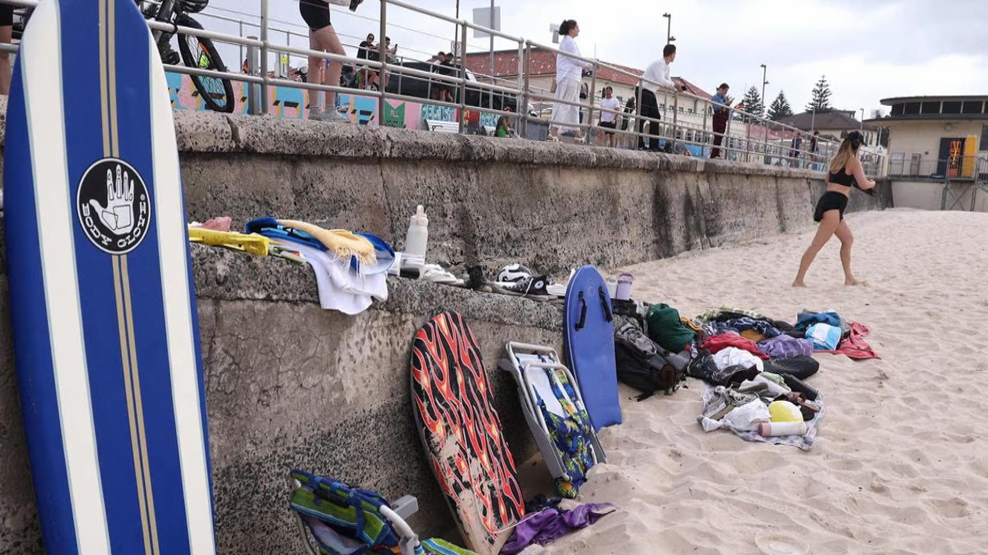 Personal belongings have been left scattered across Bondi Beach, with shoes, bags, children's toys, books and towels still lining the sand after people left them behind to run for their lives.