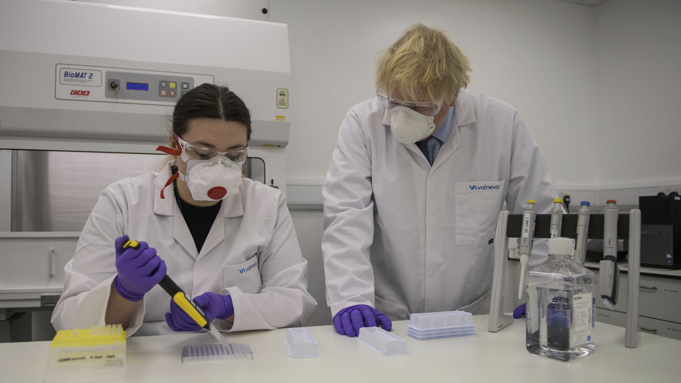 Britain's Prime Minister Boris Johnson with quality control technician Kerri Symington, visits the French biotechnology laboratory Valneva in Livingston, Scotland, Thursday Jan. 28, 2021, where they will be producing a COVID-19 vaccine on a large scale, during a visit to Scotland. 