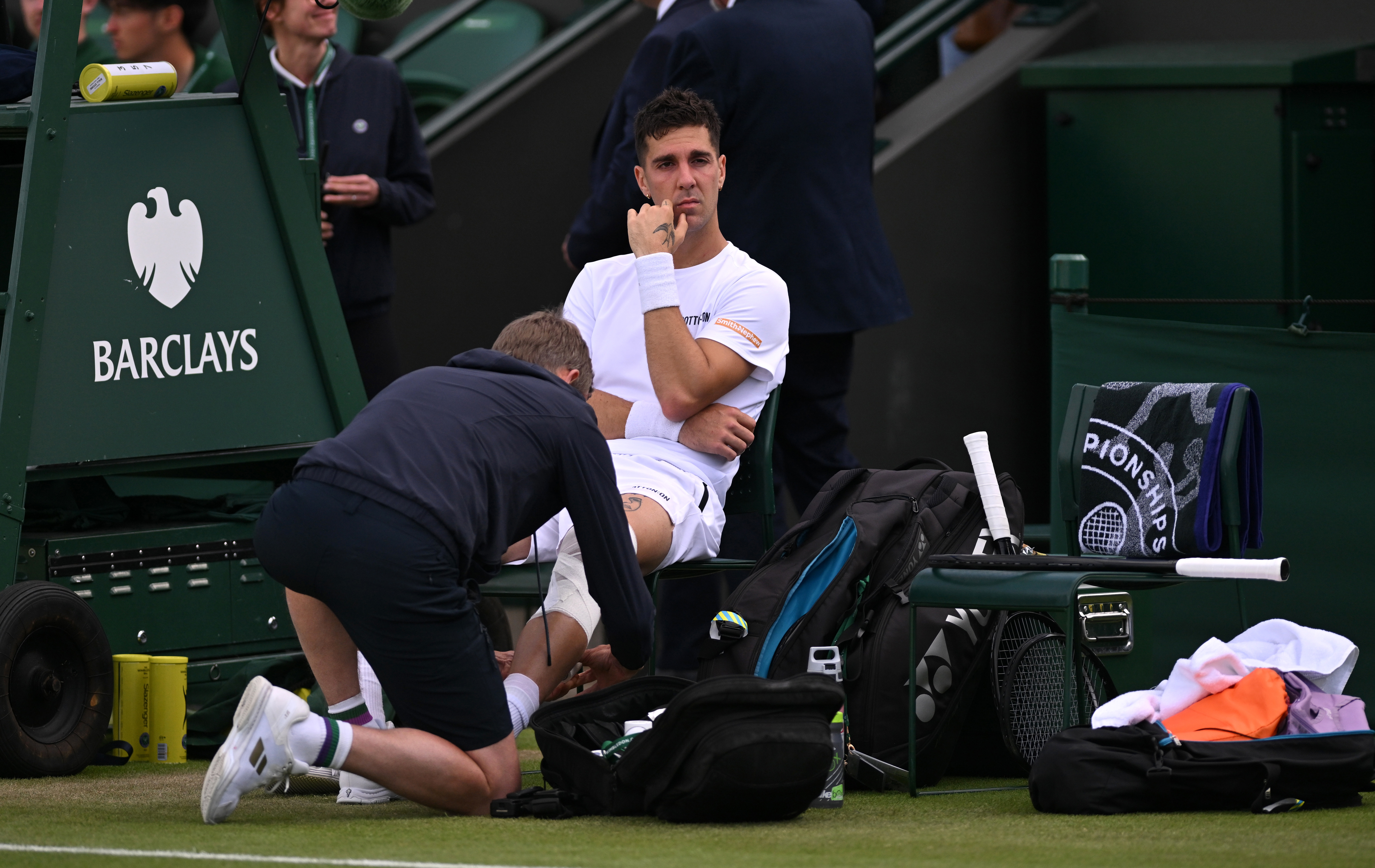 Thanasi Kokkinakis of Australia receives medical treatment before retiring injured.