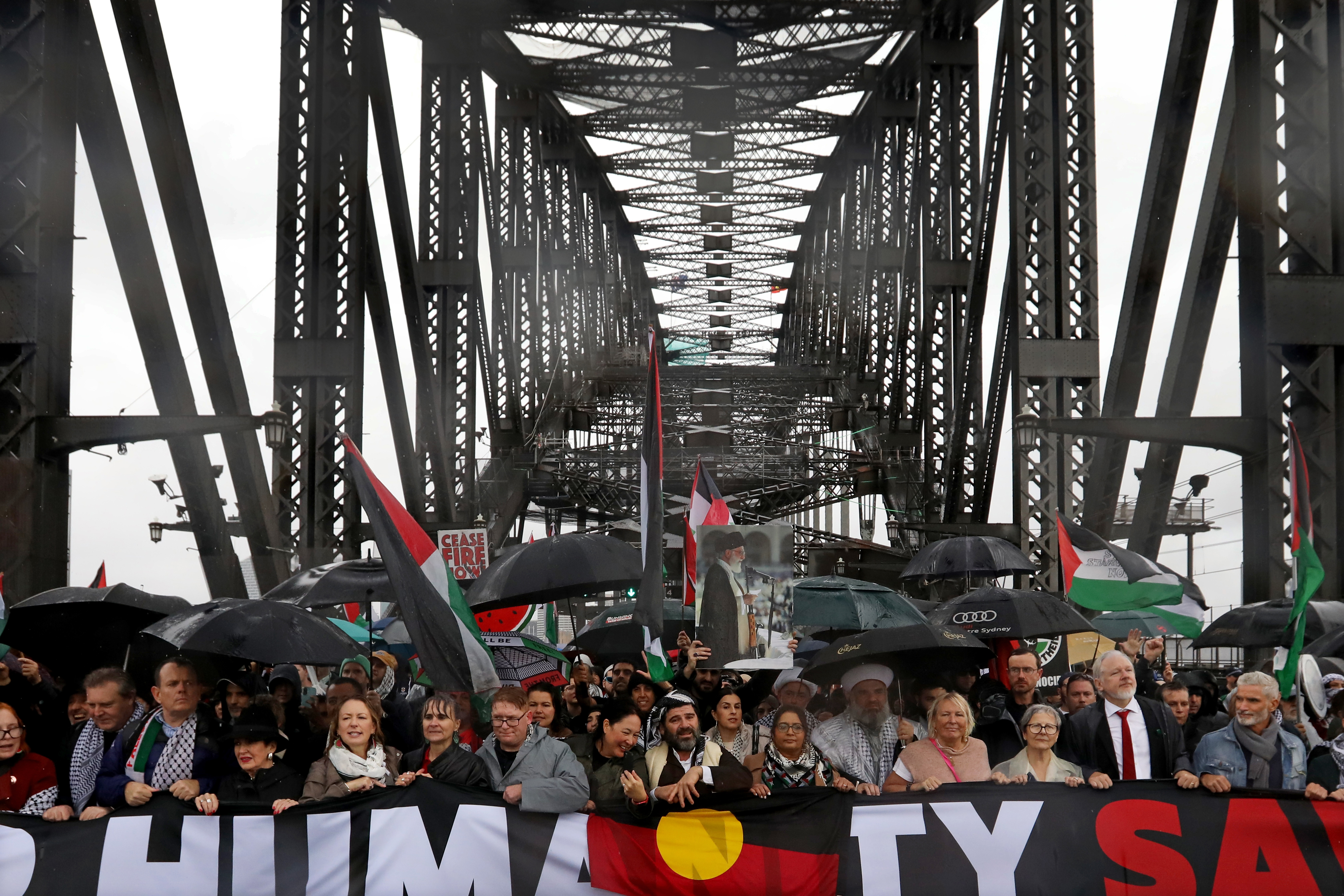 SYDNEY, AUSTRALIA - AUGUST 03: People, including Wikileaks founder Julian Assange and Craig Foster, march across the Harbour Bridge during a pro-Palestinian rally on August 03, 2025 in Sydney, Australia. Protesters in Sydney and Melbourne joined marches and actions globally, as pressure mounts on the Israeli government over a devastating humanitarian crisis unfolding as its war against Hamas continues. (Photo by Lisa Maree Williams/Getty Images)