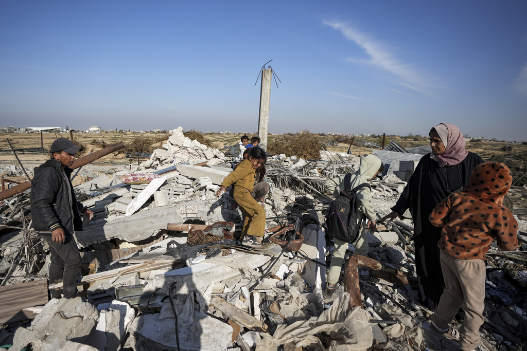 Members of the Abu Sheiban family salvage what they can of their belongings from under rubble of their destroyed home, days after the ceasefire deal between Israel and Hamas, in Rafah, southern Gaza Strip, Tuesday, Jan. 21, 2025. (AP Photo/Abdel Kareem Hana)