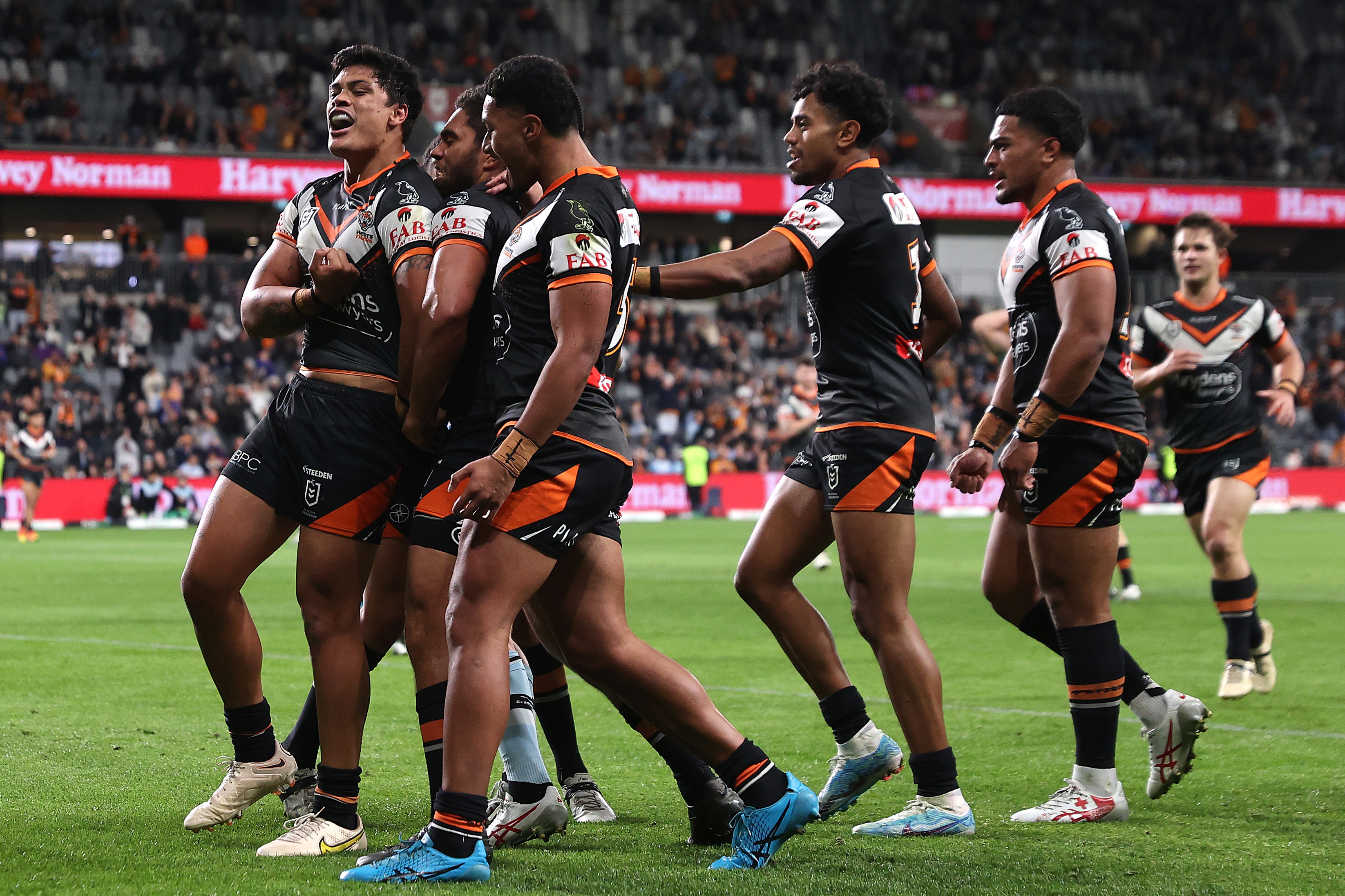SYDNEY, AUSTRALIA - JULY 06:  Tommy Talau of the Wests Tigers celebrates with team mates after scoring a try during the round 19 NRL match between Wests Tigers and Cronulla Sharks at CommBank Stadium on July 06, 2023 in Sydney, Australia. (Photo by Cameron Spencer/Getty Images)
