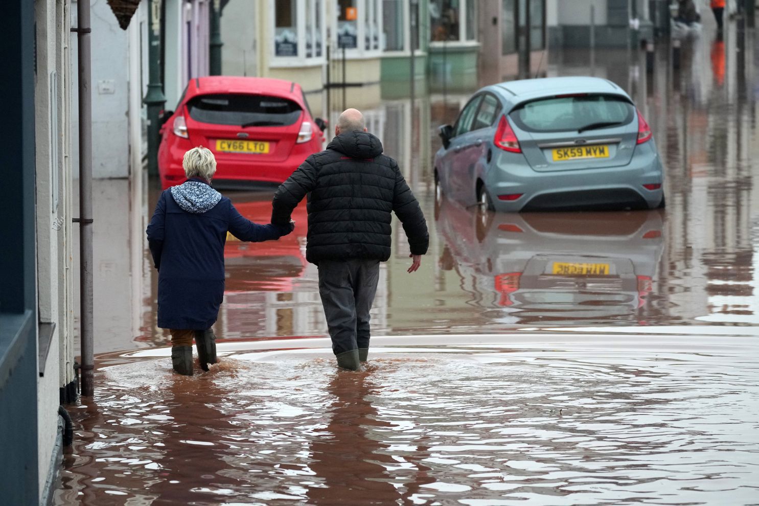 MONMOUTH, WALES - NOVEMBER 15: People wade through a flooded street on November 15, 2025 in Monmouth, Wales. Storm Claudia caused severe and widespread flooding in Monmouth and has been declared a major incident by South Wales Fire and Rescue Service. (Photo by Christopher Furlong/Getty Images)
