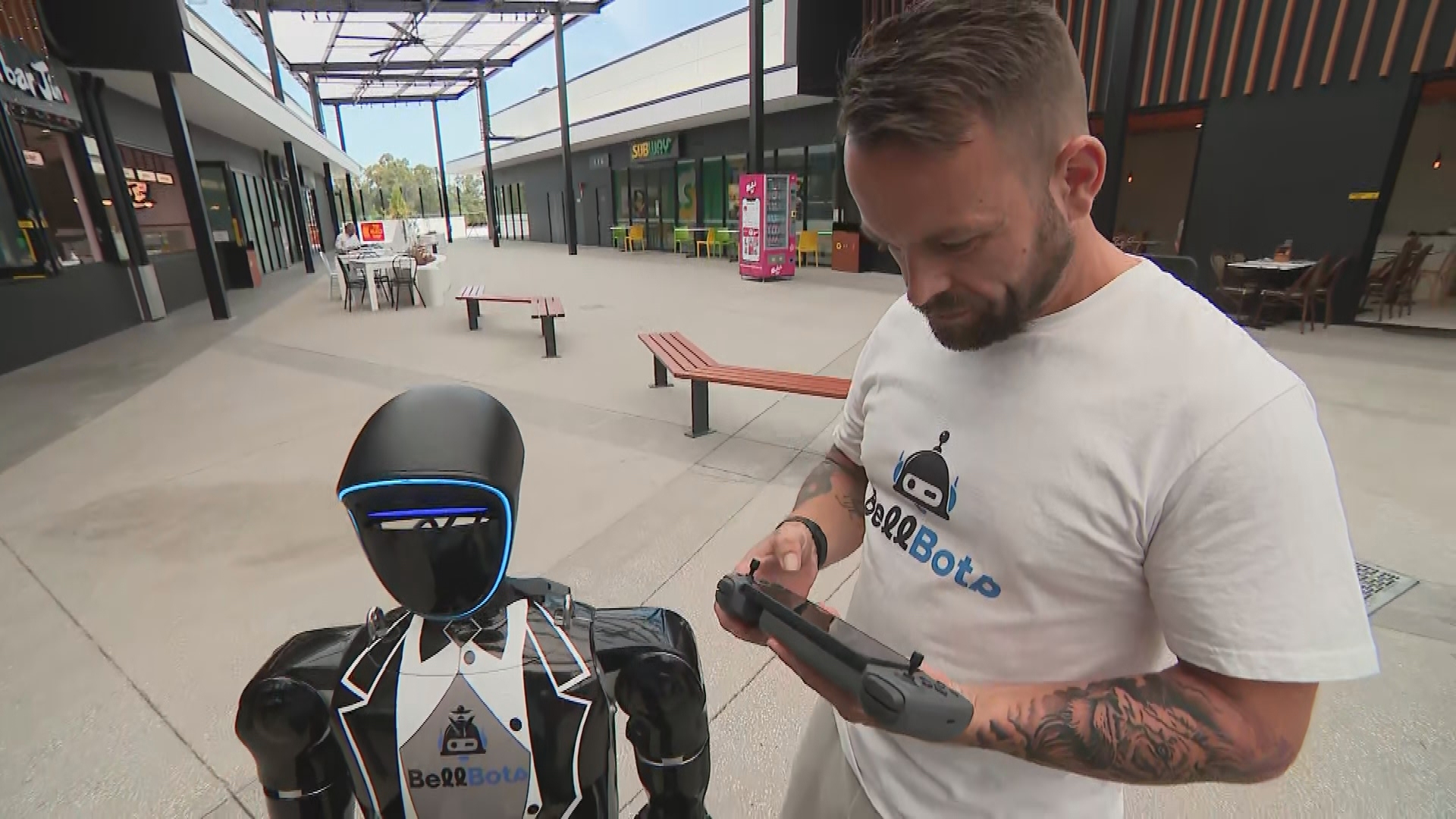 Andrew Bell from BellBots standing next to Wally the AI humanoid. 