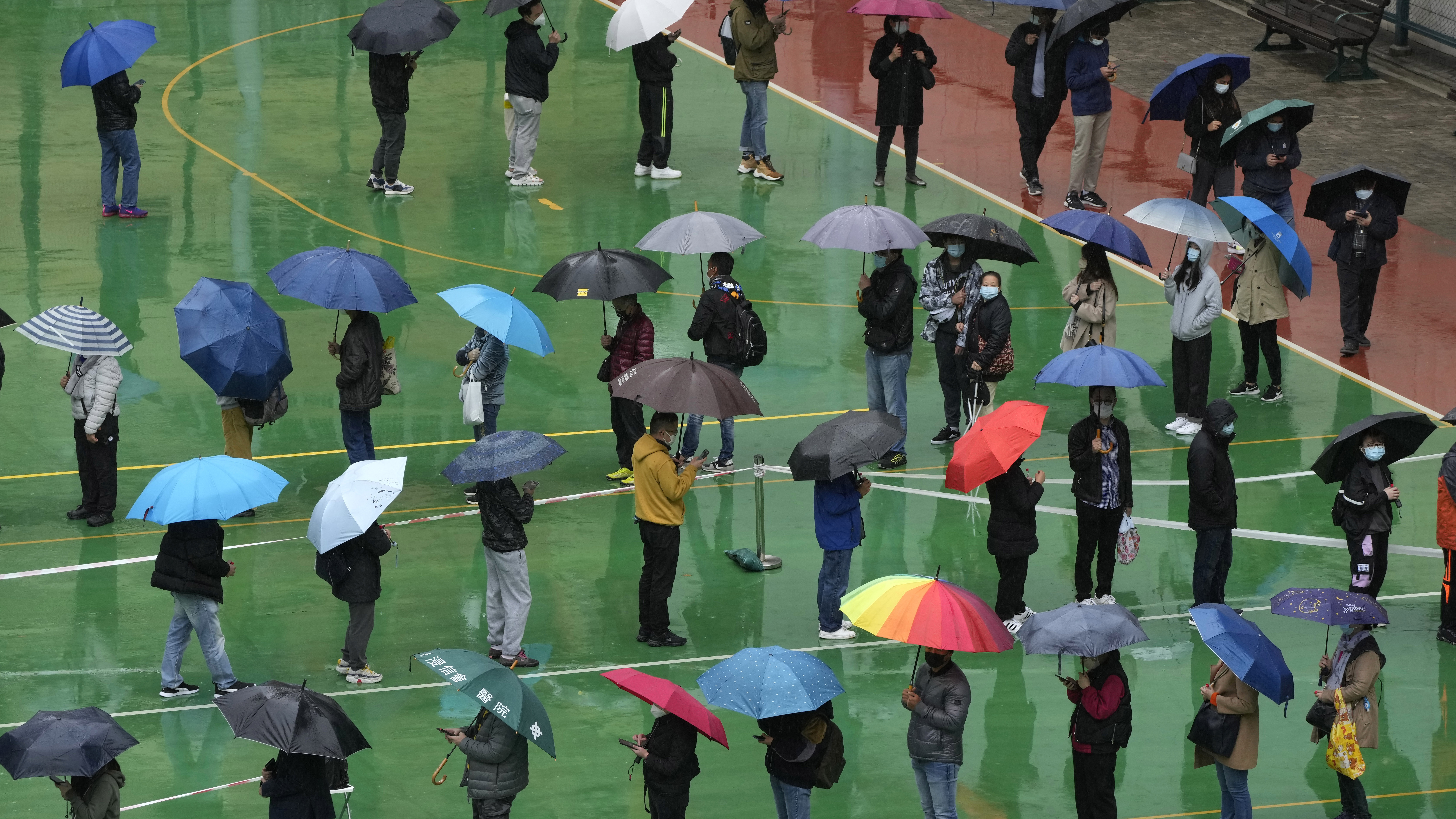 Residents line up to get tested for the coronavirus at a temporary testing centre despite the rain in Hong Kong.