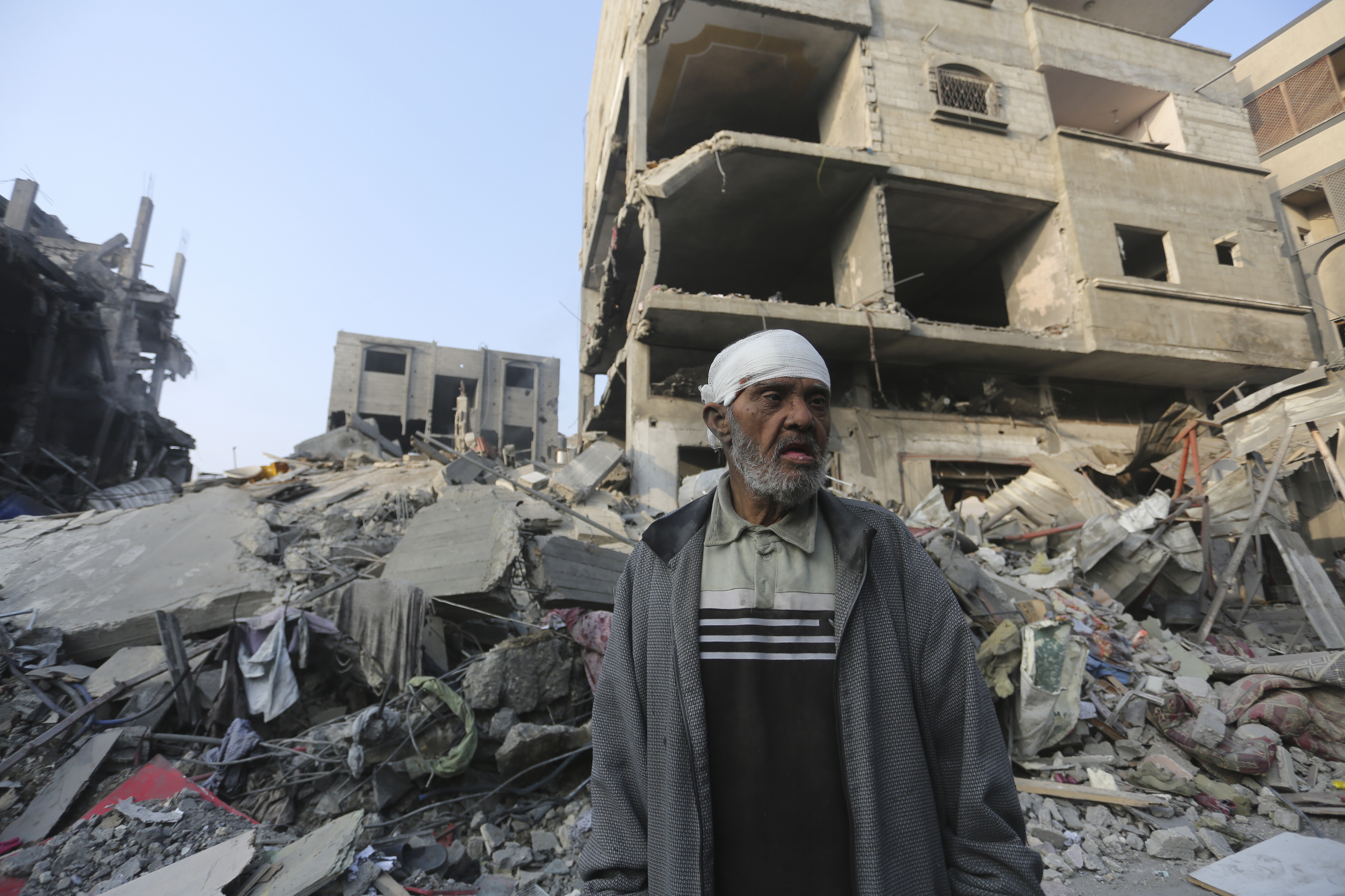 A Palestinian stands outside the building destroyed in the Israeli bombardment of the Gaza Strip