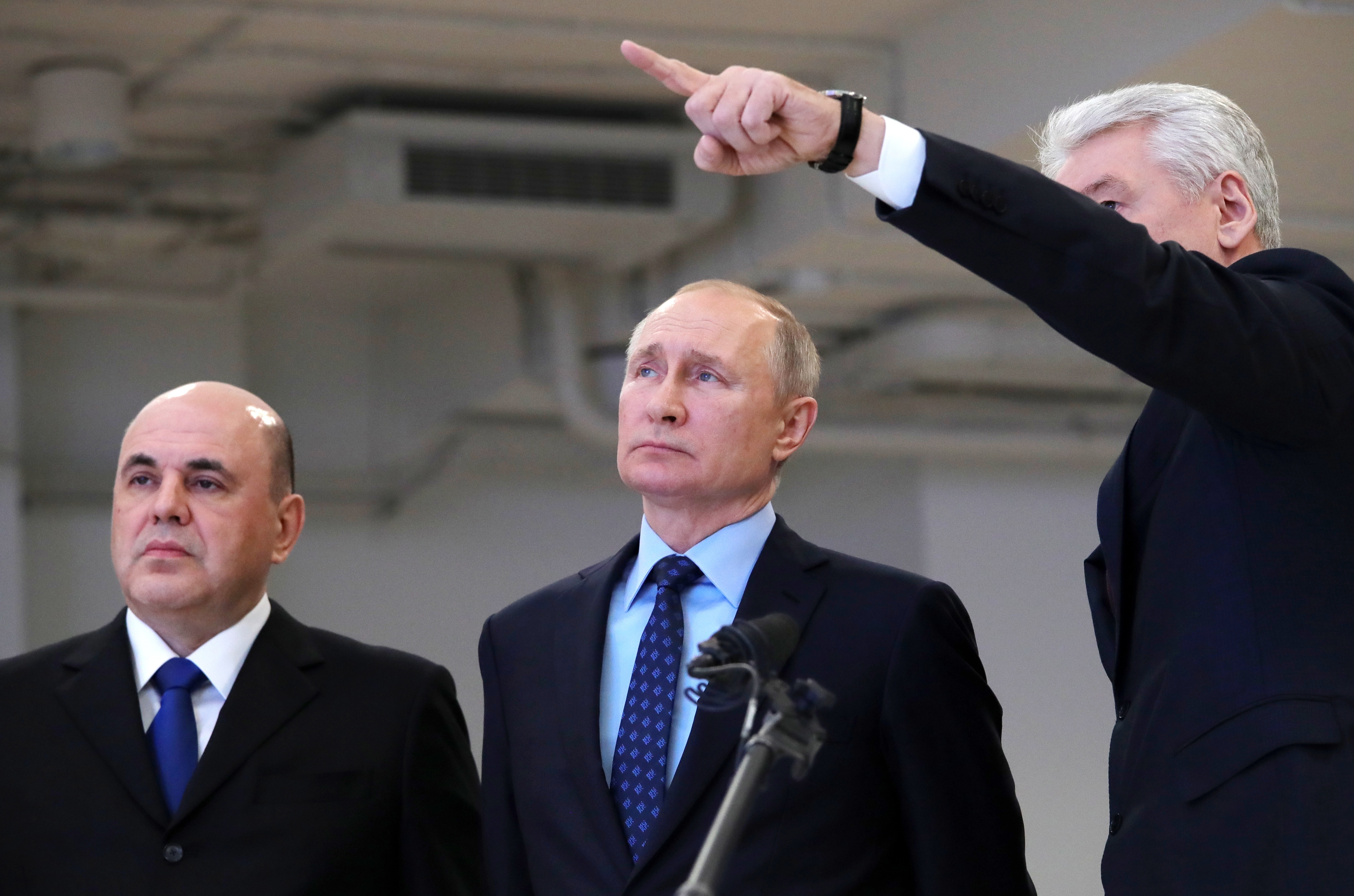 Moscow Mayor Sergei Sobyanin, right, points as he speaks to Russian President Vladimir Putin, center, and Prime Minister Mikhail Mishustin, left, during their visit a call centre of the emergency response centre on control and monitoring of the coronavirus disease.