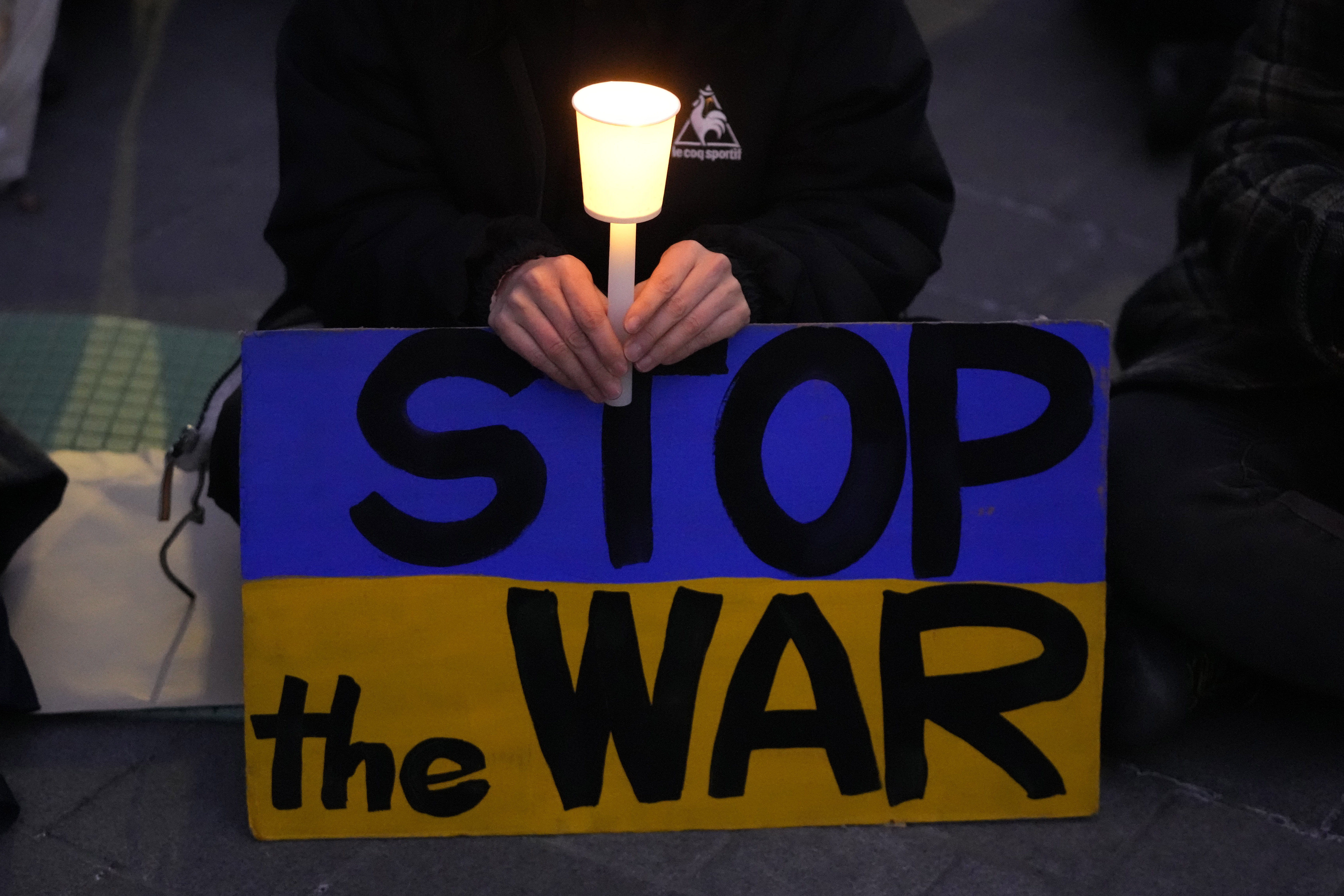 A participant holds a candle during a candle light vigil in support of Ukraine, near the Russia Embassy in Seoul, South Korea, Friday, March 4, 2022