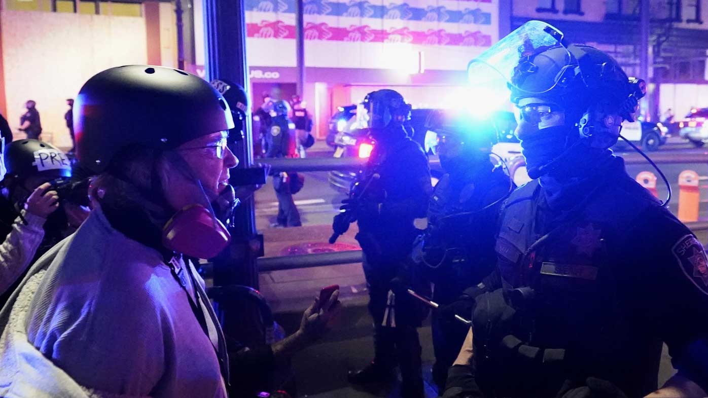 Police officers stand in front of protesters in Portland, Oregon.