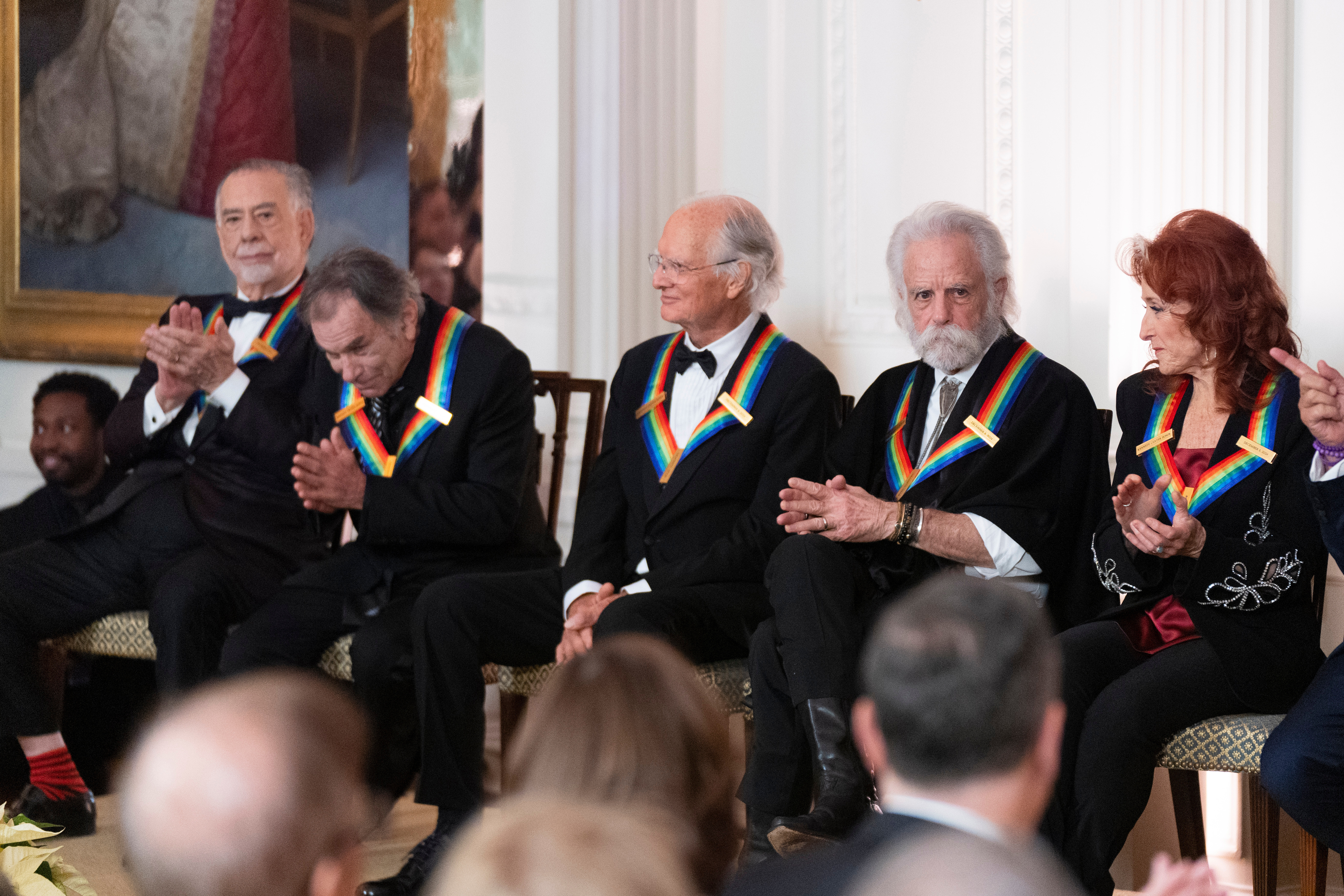 FILE - Kennedy Center Honors recipients from left; filmmaker Francis Ford Coppola, the legendary American rock band the Grateful Dead band members Mickey Hart, Bill Kreutzmann Bob Weir and blues rock singer-songwriter and guitarist Bonnie Raitt, applaud at at the 2024 Kennedy Center Honors reception in the East Room of the White House, Sunday, Dec. 8, 2024, in Washington. (AP Photo/Manuel Balce Ceneta,File)