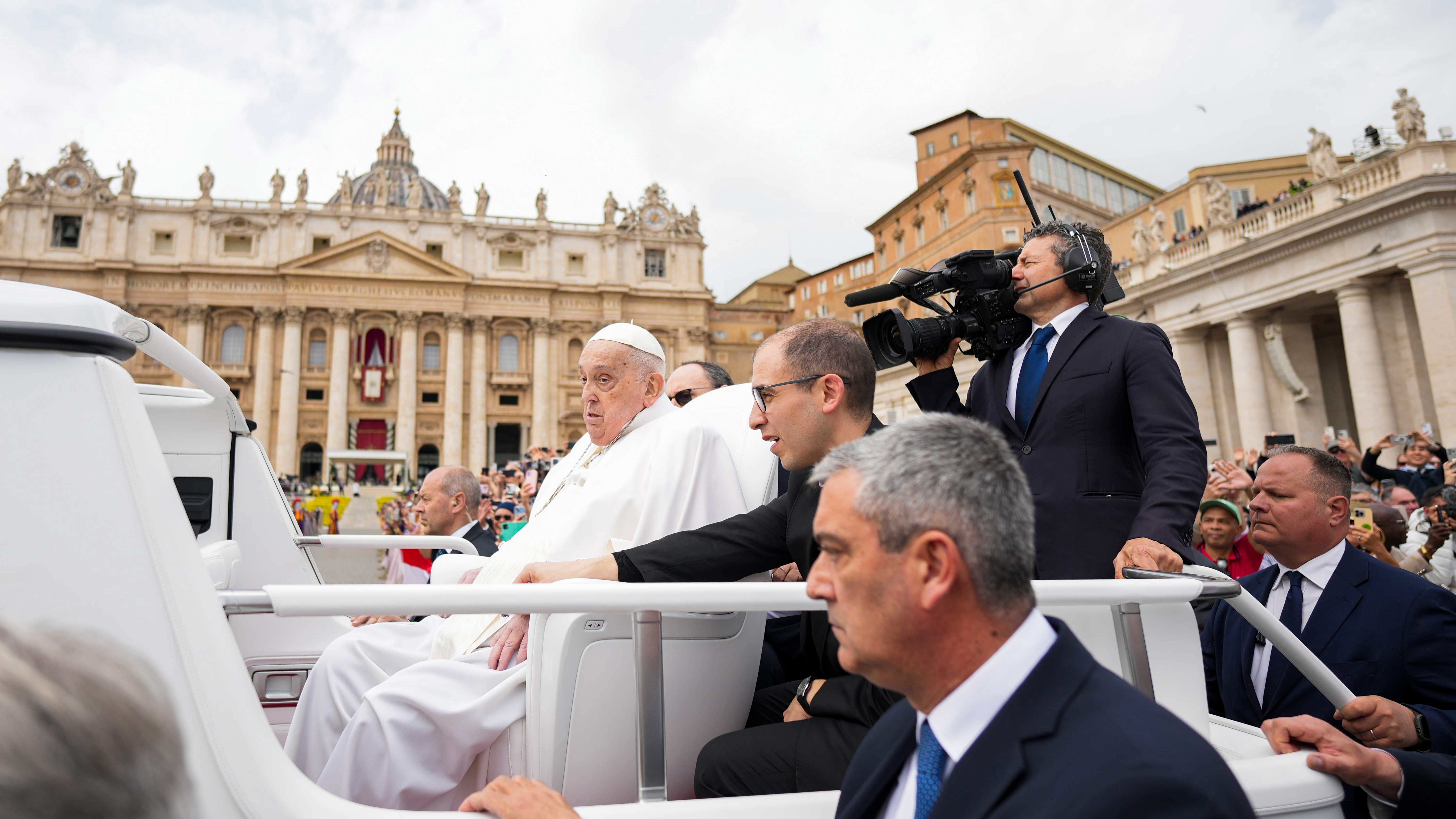 Pope Francis tours St. Peter's Square in his popemobile with his nurse by his side.