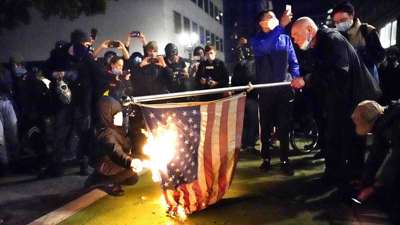 A protester lights an American flag on fire during a demonstration in Portland, Oregon.