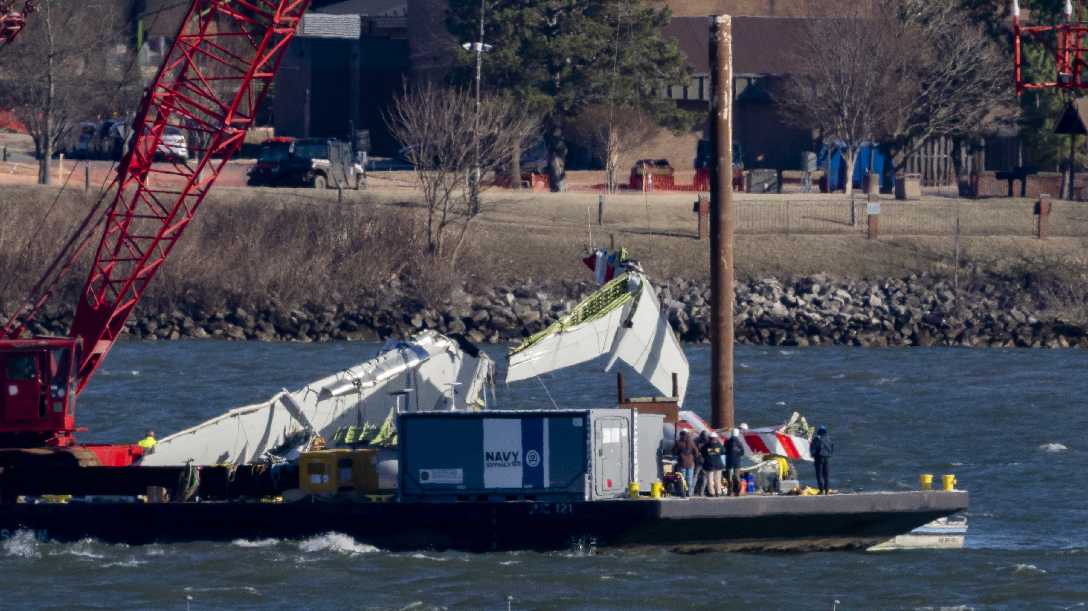 Se levanta un trozo de restos del agua hacia un recipiente de rescate, cerca del sitio en el río Potomac de una colisión en el aire entre un jet American Airlines y un helicóptero de halcón negro, en el Aeropuerto Nacional Ronald Reagan Washington.