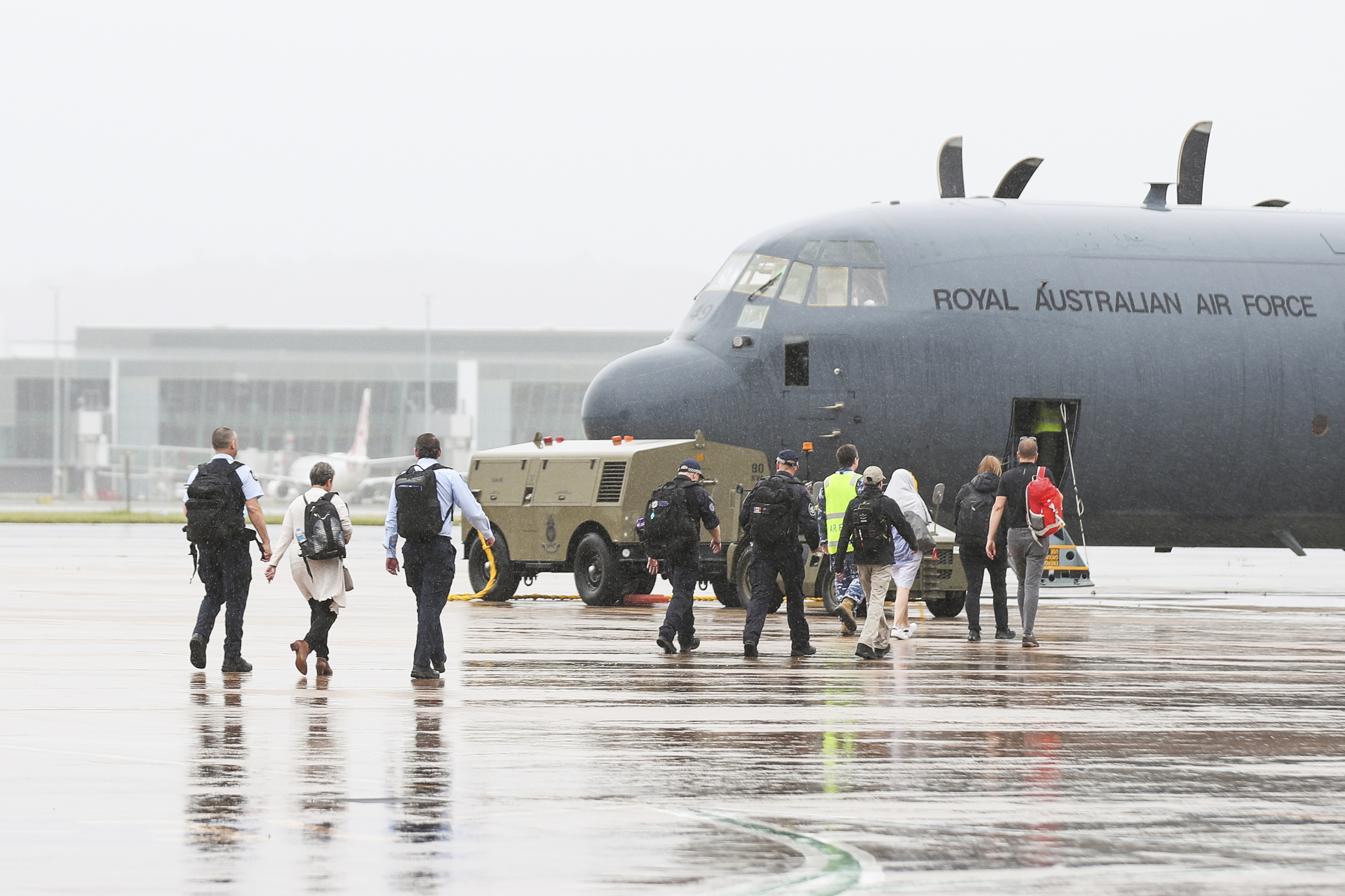Australian Federal Police personnel are seen boarding a RAAF C-130 Hercules  bound for the Solomon Islands.