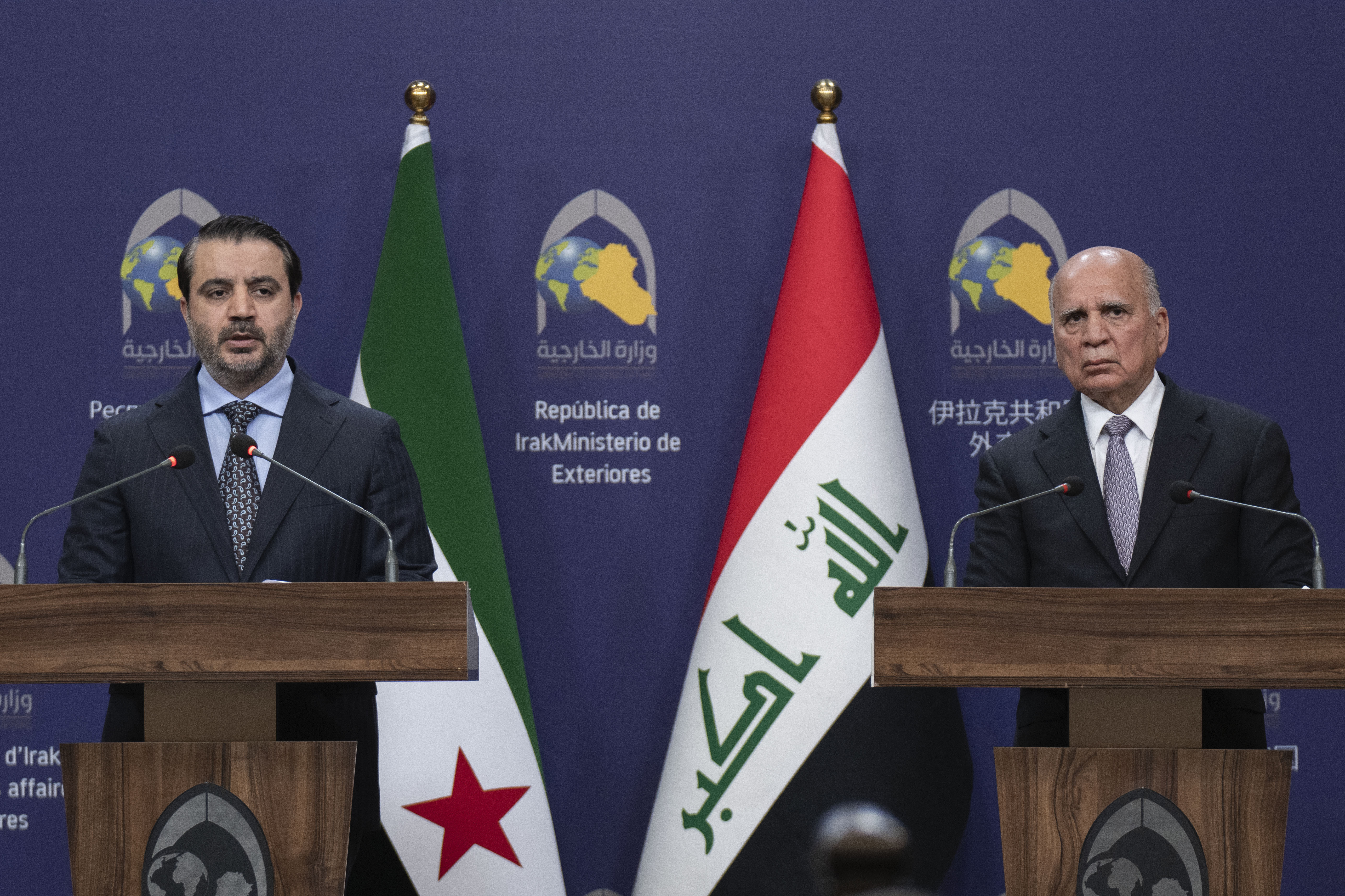 Syrian Foreign Minister Asaad al-Shaybani, left, speaks during a news conference with his Iraqi counterpart Fouad Hussein following their meeting, in Baghdad, Iraq, Friday, March.14, 2025. (AP Photo/Hadi Mizban)