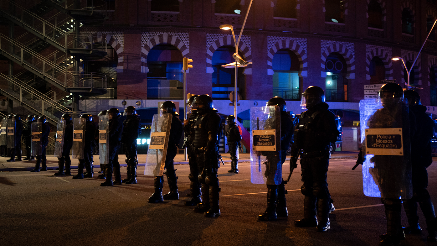 Police officers stand in position blocking a street during a protest condemning the arrest of rap singer Pablo Hasél in Barcelona, Spain, Sunday, Feb. 21, 2021. (AP Photo/Felipe Dana)