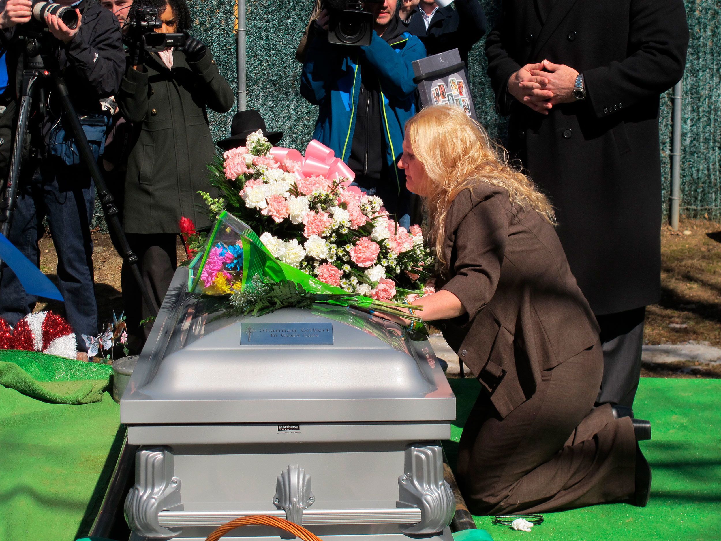 Mari Gilbert kneels over the coffin of her daughter Shannan Gilbert at Amityville Cemetery on March 12, 2015.