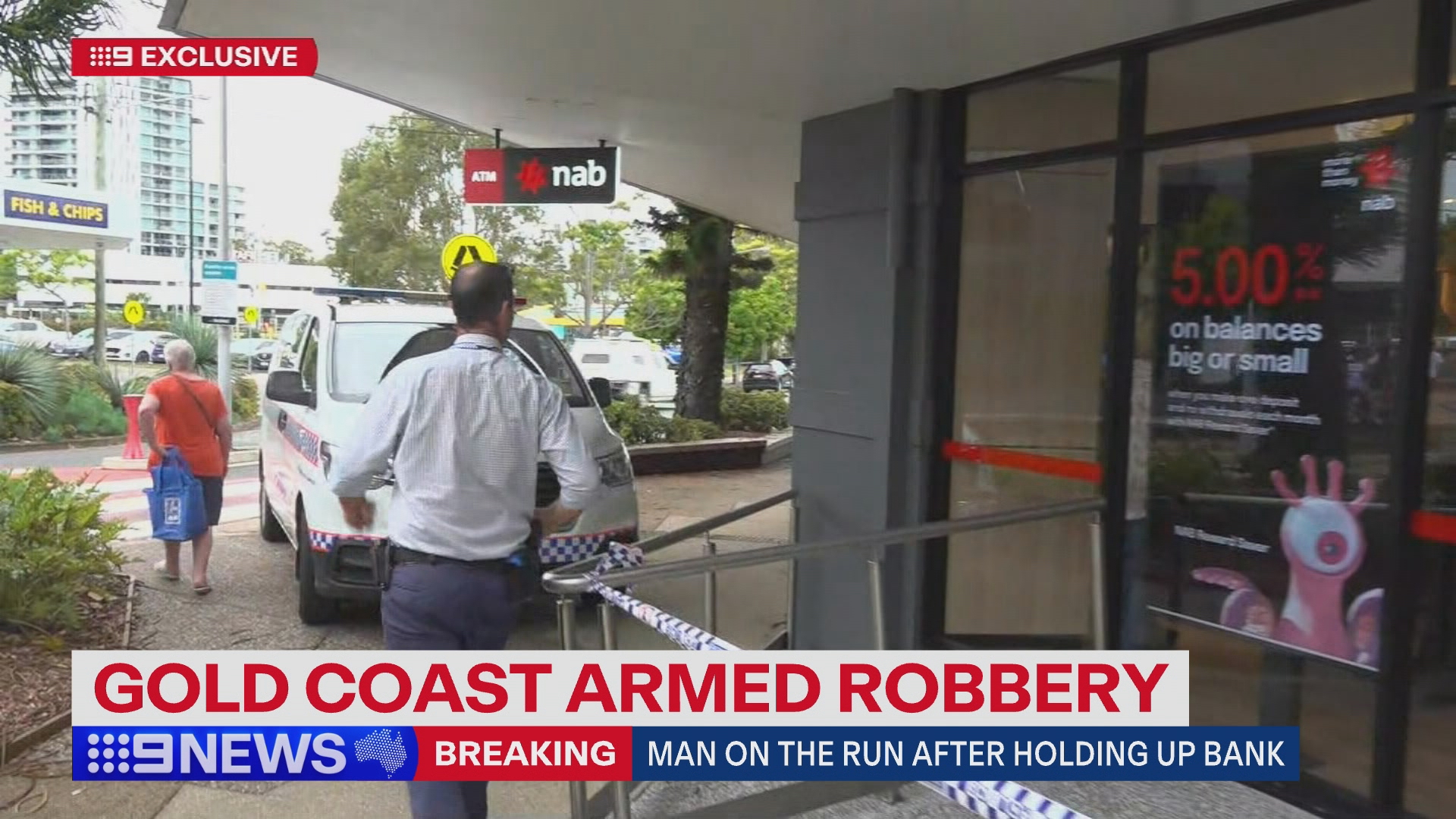 A man is on the run after allegedly robbing a NAB branch on the Gold Coast armed with a knife.﻿