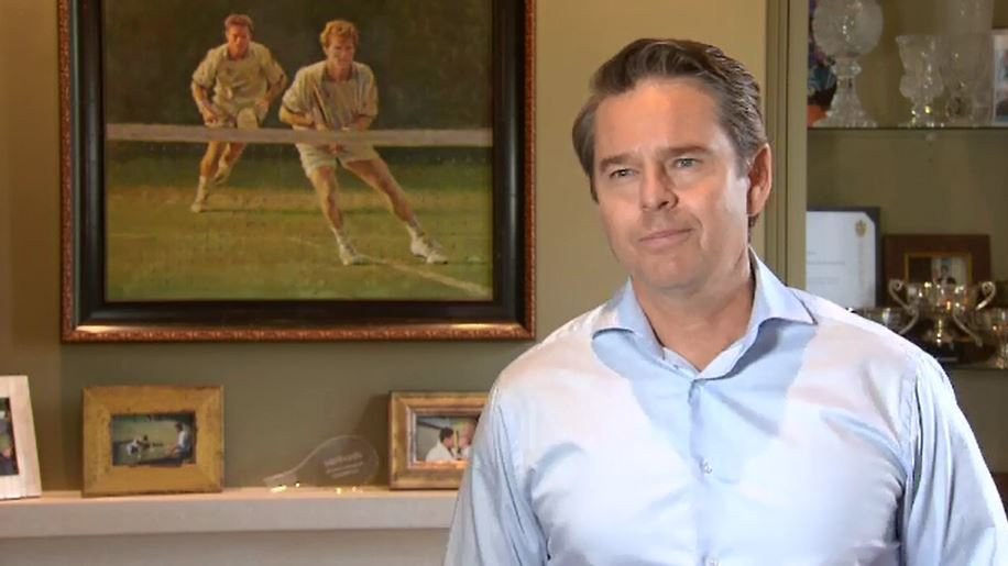 Todd Woodbridge in front of a portrait of the Woodies in full flight.