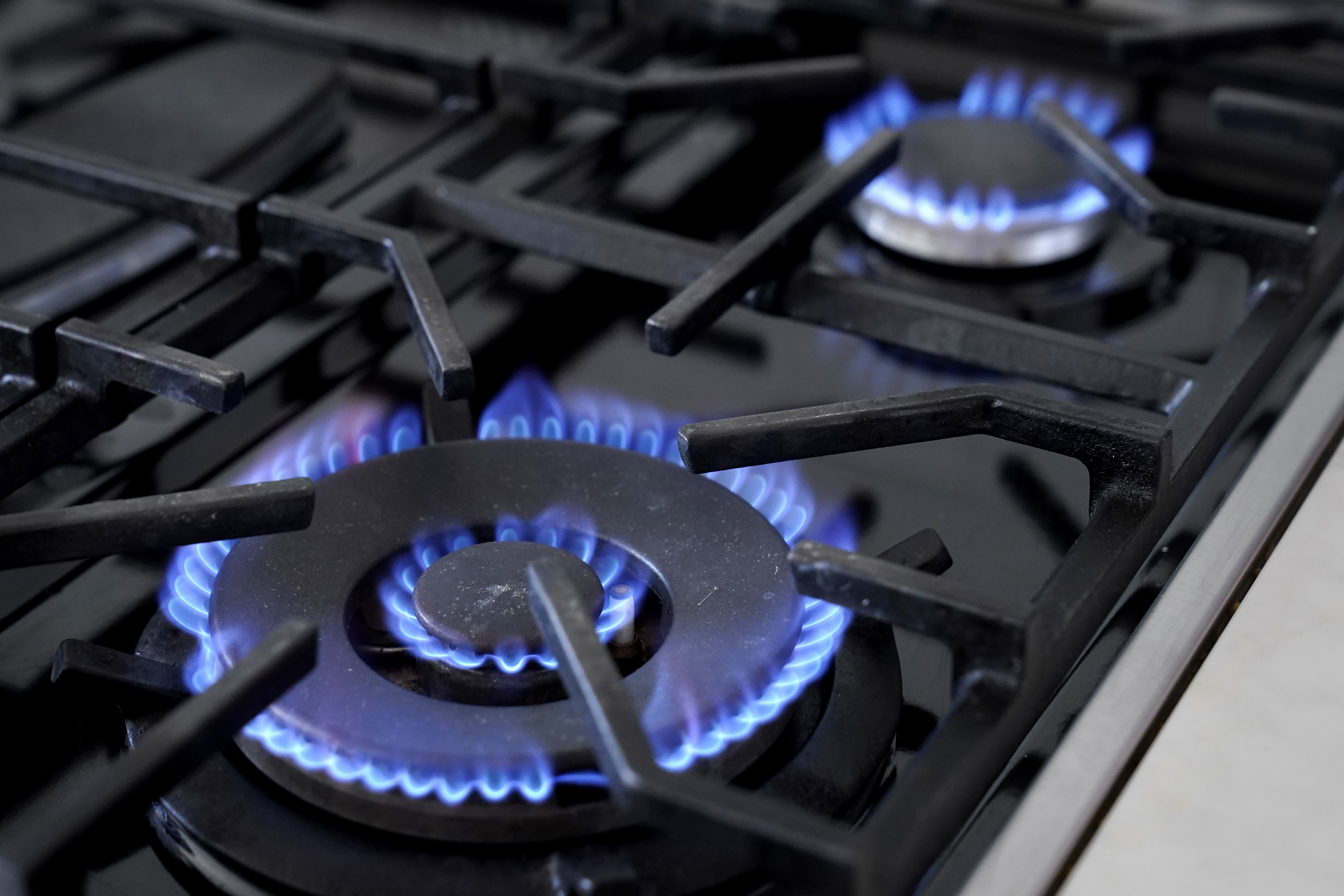 Flames emerge from burners on a natural gas stove.