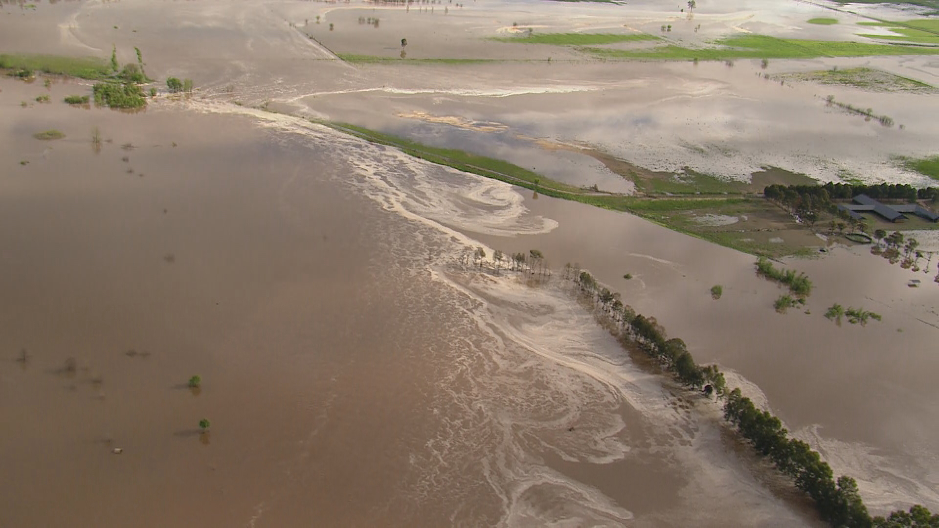 Flood waters swirl around farmland in Sydney's north west.