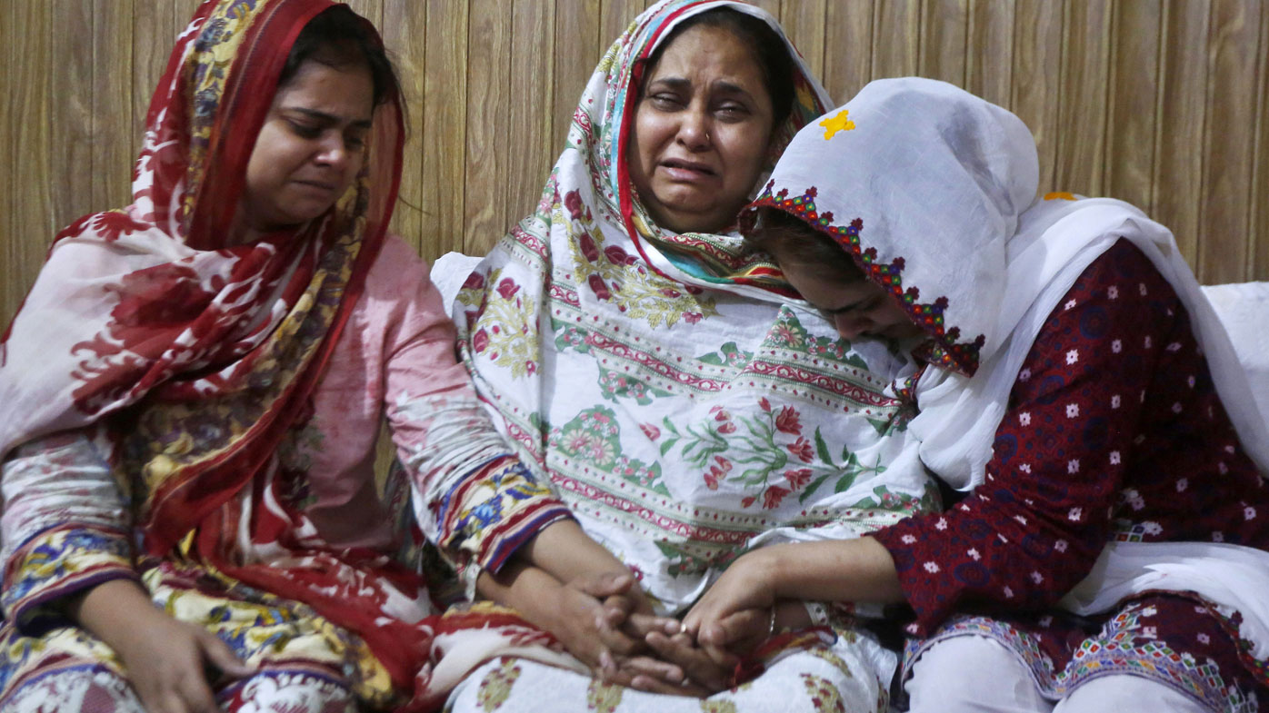 Family members of an air hostess Anam Maqsood, who was killed in Friday's plane crash, mourn for her death at their home in Lahore, Pakistan, Saturday, May 23, 2020