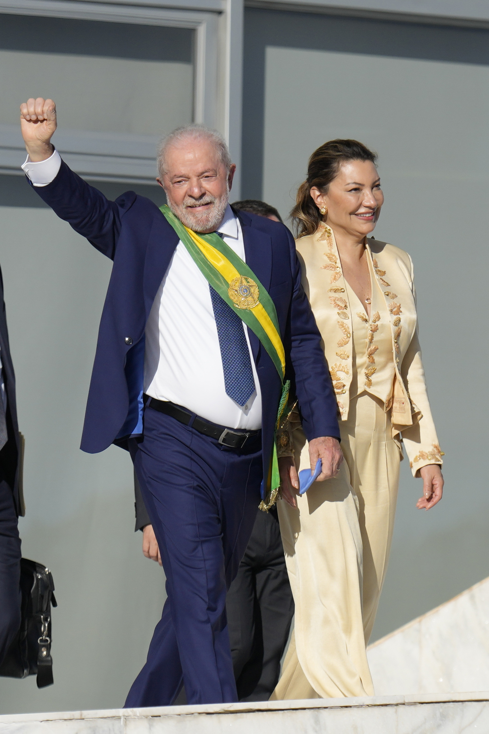 President Luiz Inacio Lula da Silva, left, waves to supporters as he holds hands with his wife Rosangela Silva at the Planalto Palace in Brasilia, Brazil, Sunday, Jan. 1, 2023. (AP Photo/Andre Penner)