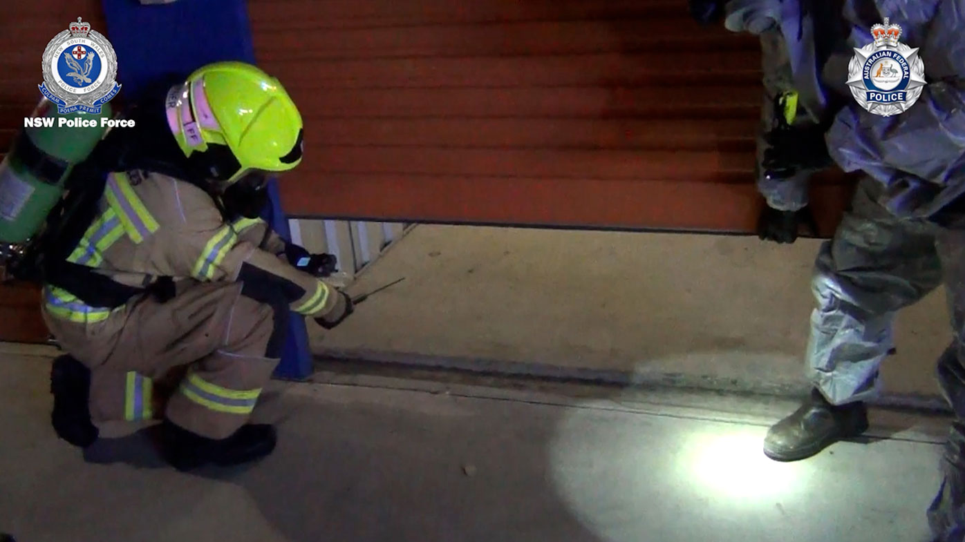 Assisted by a fireman, police open the Prospect storage facility. 