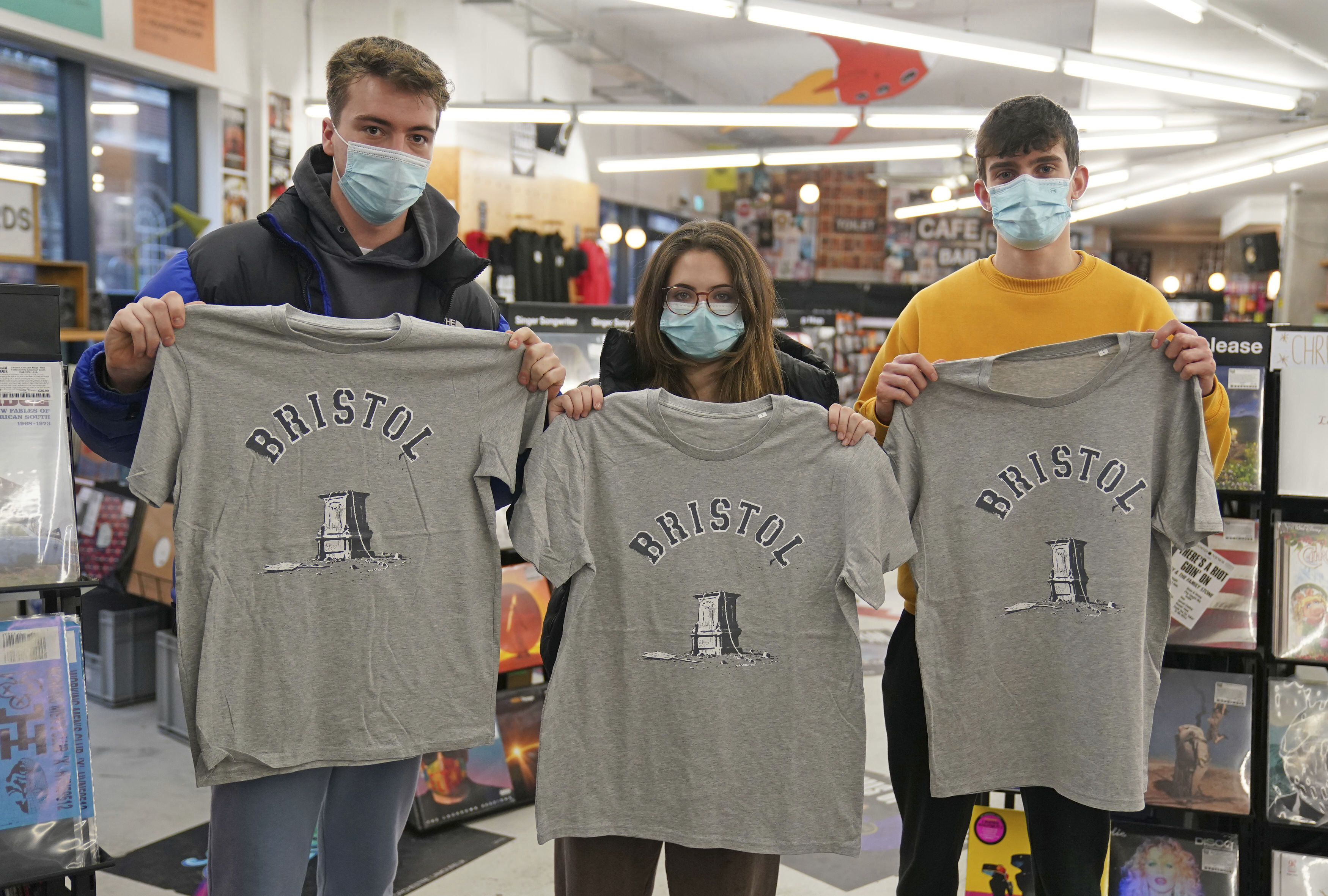 Customers inside Rough Trade in Bristol, England, Saturday Dec. 11, 2021, hold T-shirts designed by street artist Banksy