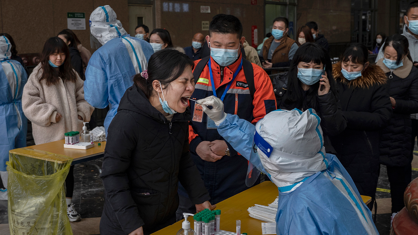 Health workers give nucleic acid tests to detect COVID-19 at a pop-up mass tasting site at an office building on March 22, 2022 in Beijing, China.