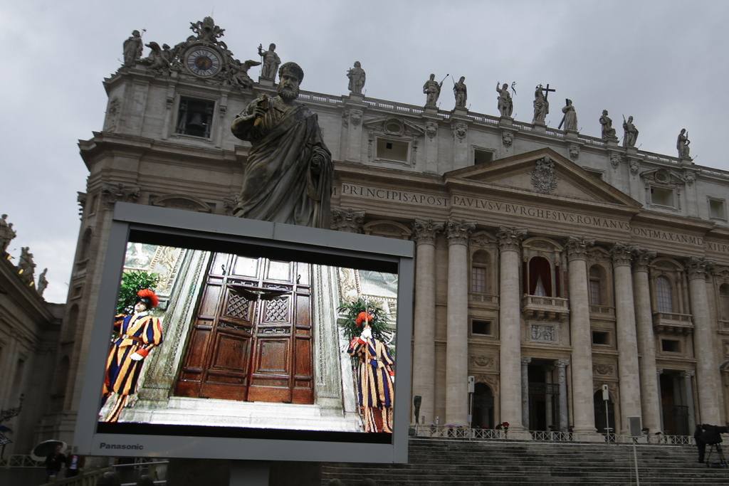 A file image of a giant monitor in St. Peter's Square at the Vatican, from 2013 that shows the heavy wooden door to the Sistine Chapel being closed and locked, signalling the start of the conclave to elect a new pope.