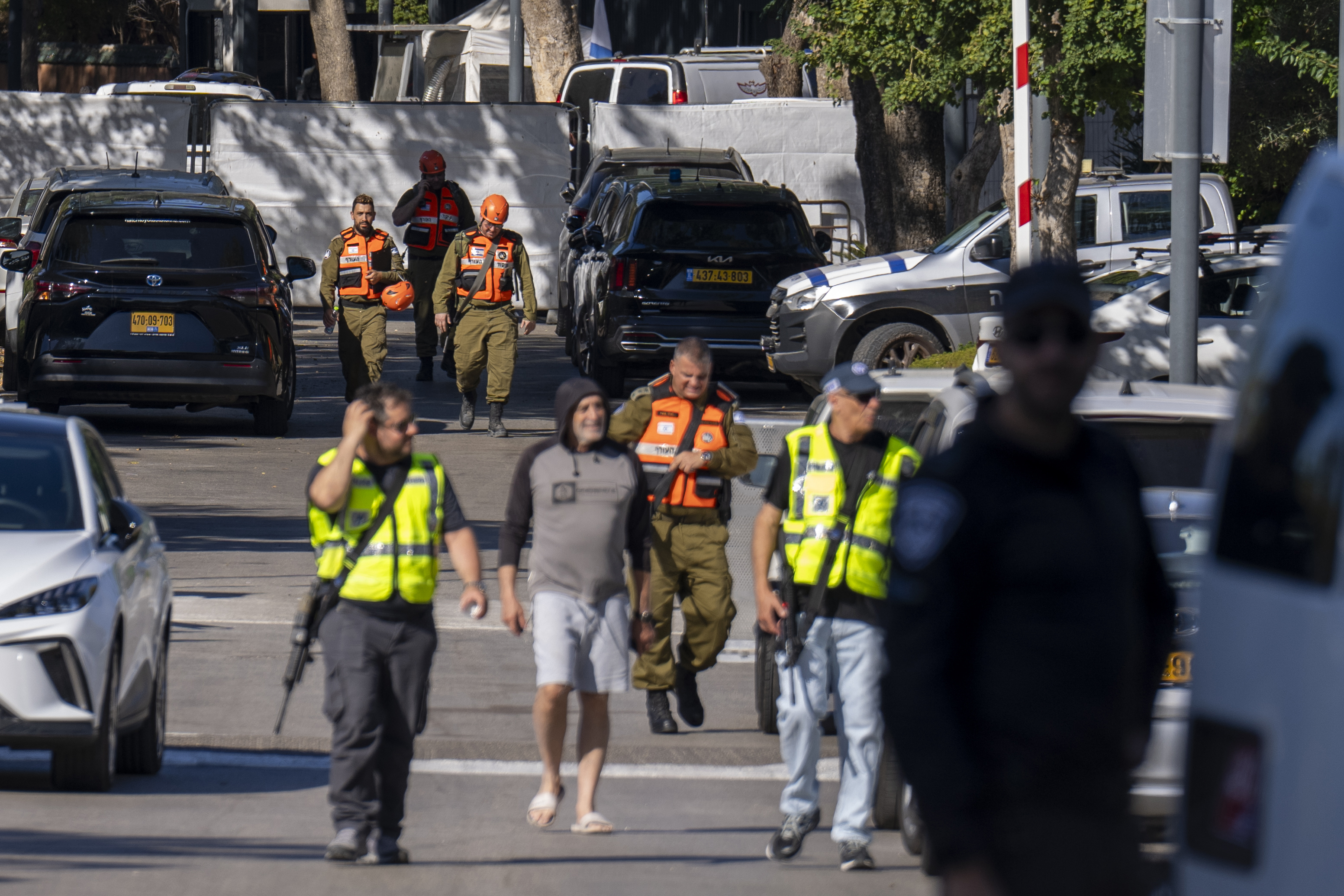 Officers from the Israeli Home Front Command military unit walk on a road near where Israel's government says a drone launched toward Israeli Prime Minister Benjamin Netanyahu's house in Caesarea, Israel, Saturday, Oct. 19, 2024. 