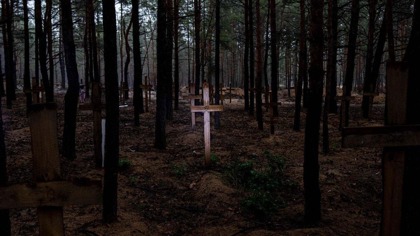 Unidentified graves of civilians and Ukrainian soldiers are marked with a cross