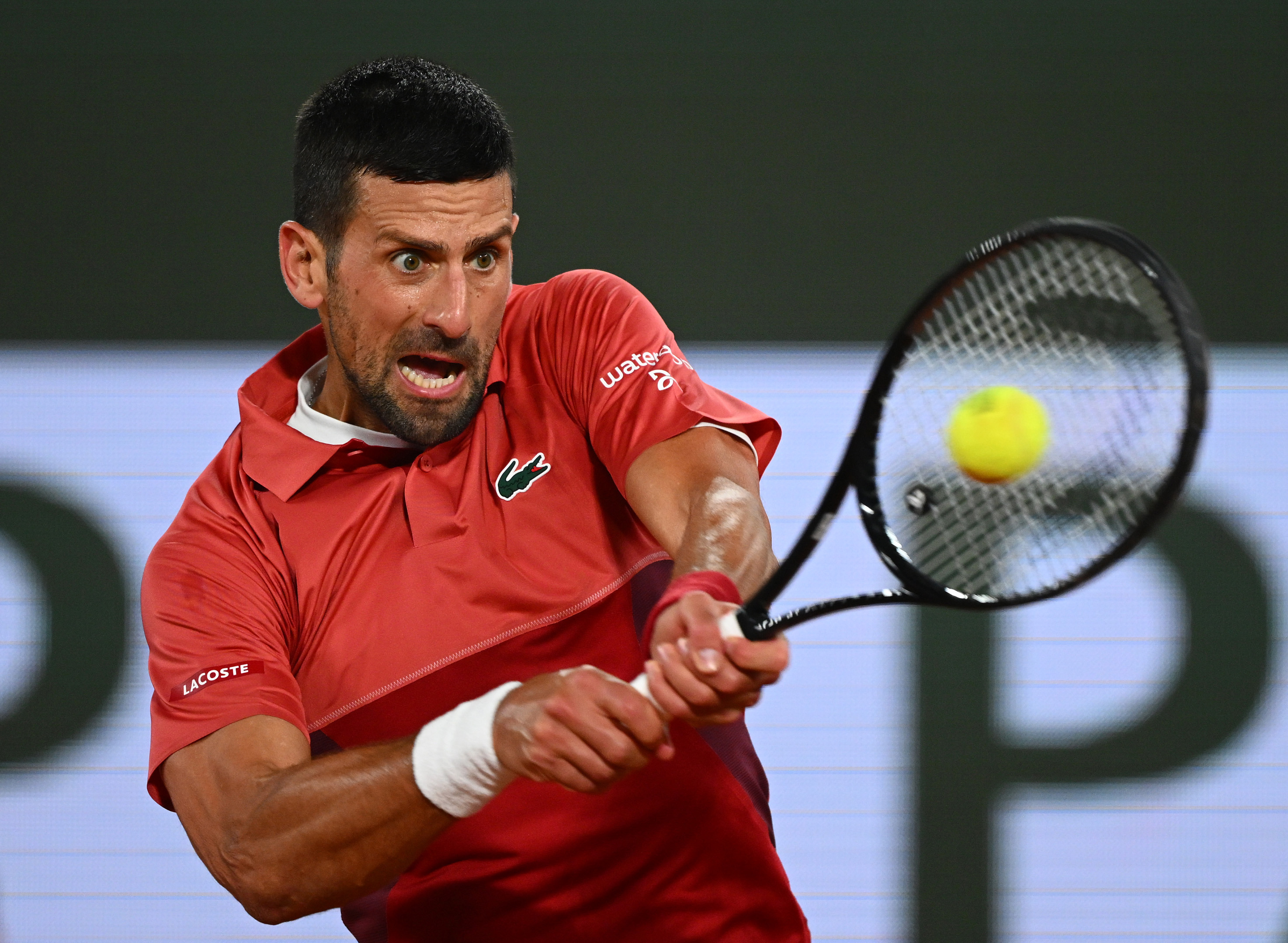 Novak Djokovic of Serbia plays a backhand against Lorenzo Musetti of Italy.