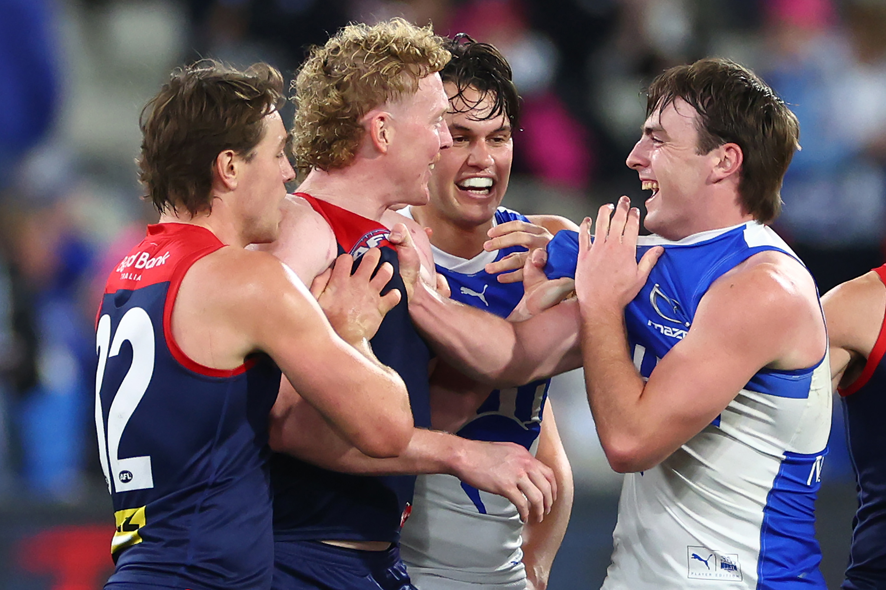 Clayton Oliver of the Demons and George Wardlaw of the Kangaroos wrestle during round 15.