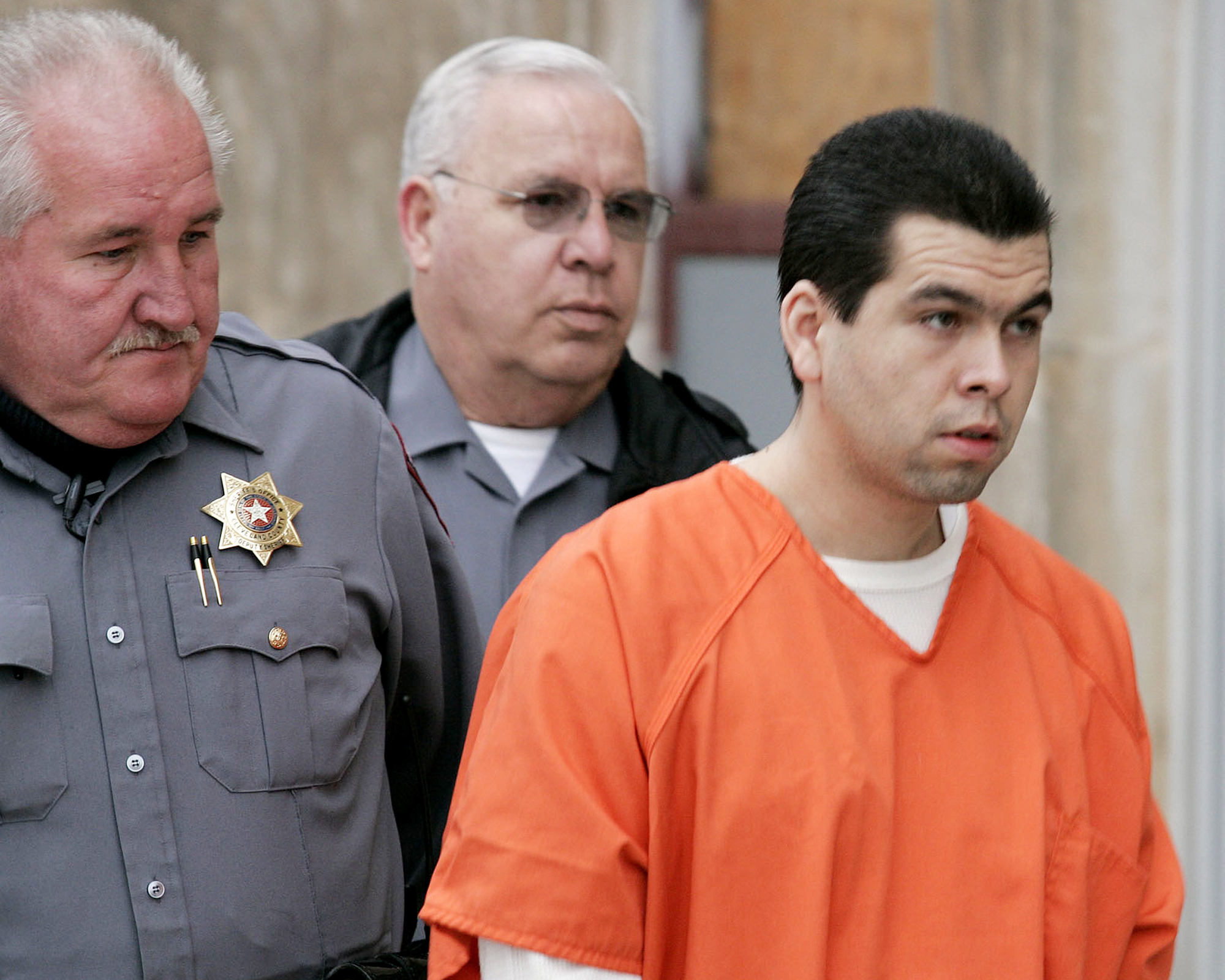 Anthony Sánchez, a la derecha, es escoltado a una sala del tribunal del condado de Cleveland para una audiencia preliminar en Norman, Oklahoma, el 23 de febrero de 2005