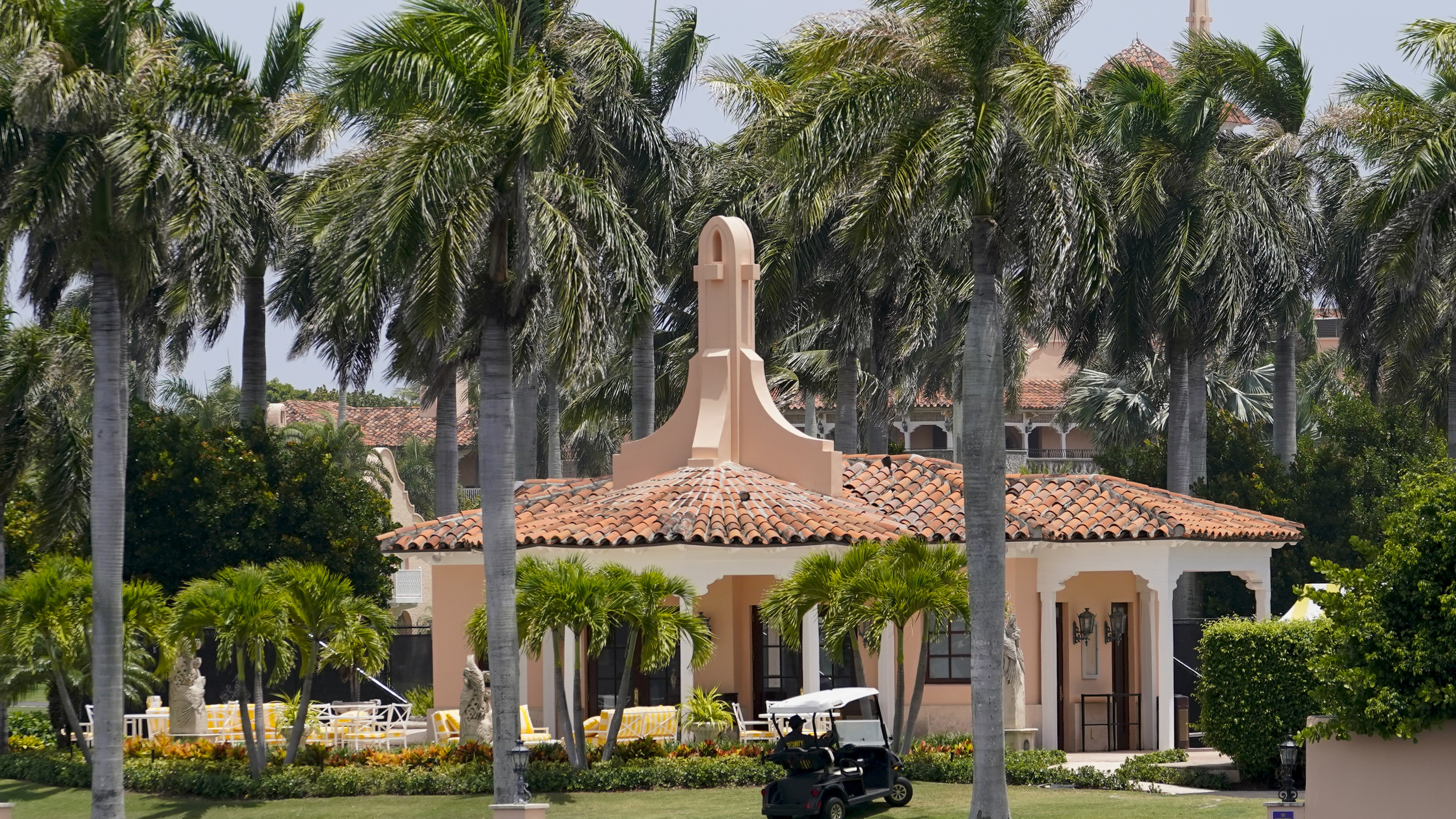 Seguridad se mueve en un carrito de golf en la finca Mar-a-Lago del expresidente Donald Trump en Palm Beach, Florida.