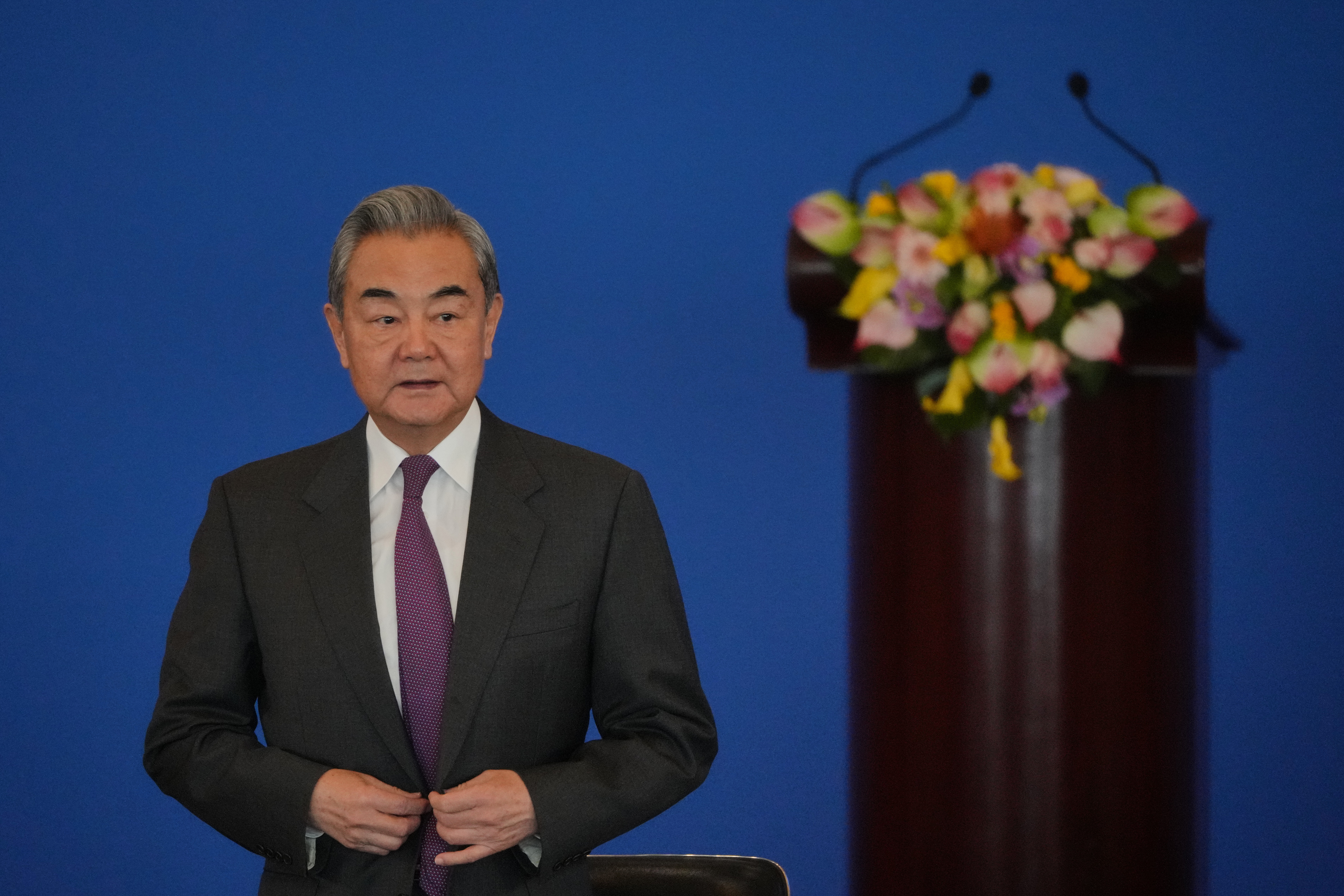 China's Foreign Minister Wang Yi looks as he arrives to deliver an opening speech for the annual symposium on the international situation and China's foreign relations held by China Institute of International Studies at the Diaoyutai State Guesthouse, in Beijing, Tuesday, Dec. 30, 2025. (AP Photo/Andy Wong)