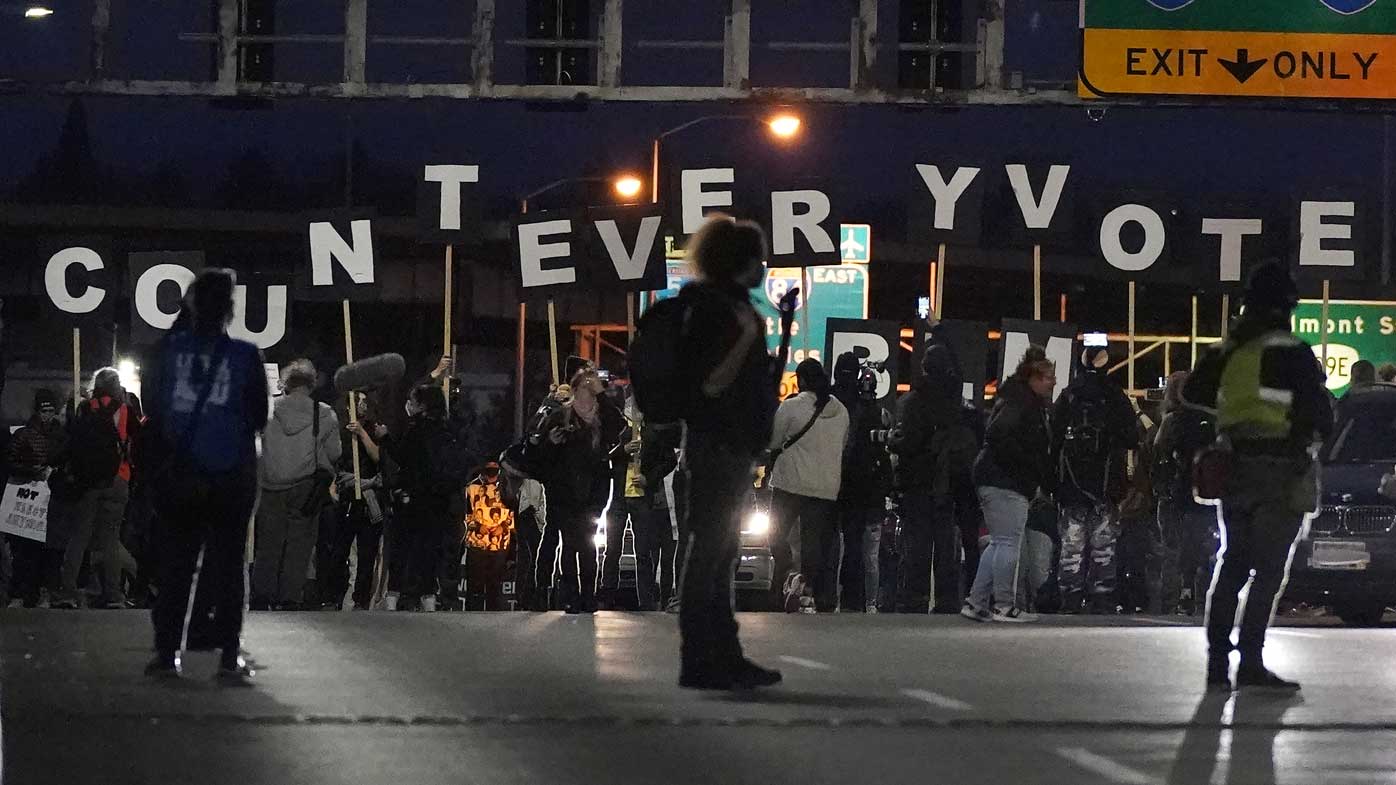 Protesters hold letters that spell Count Every Vote as they cross an overpass while marching in Portland.