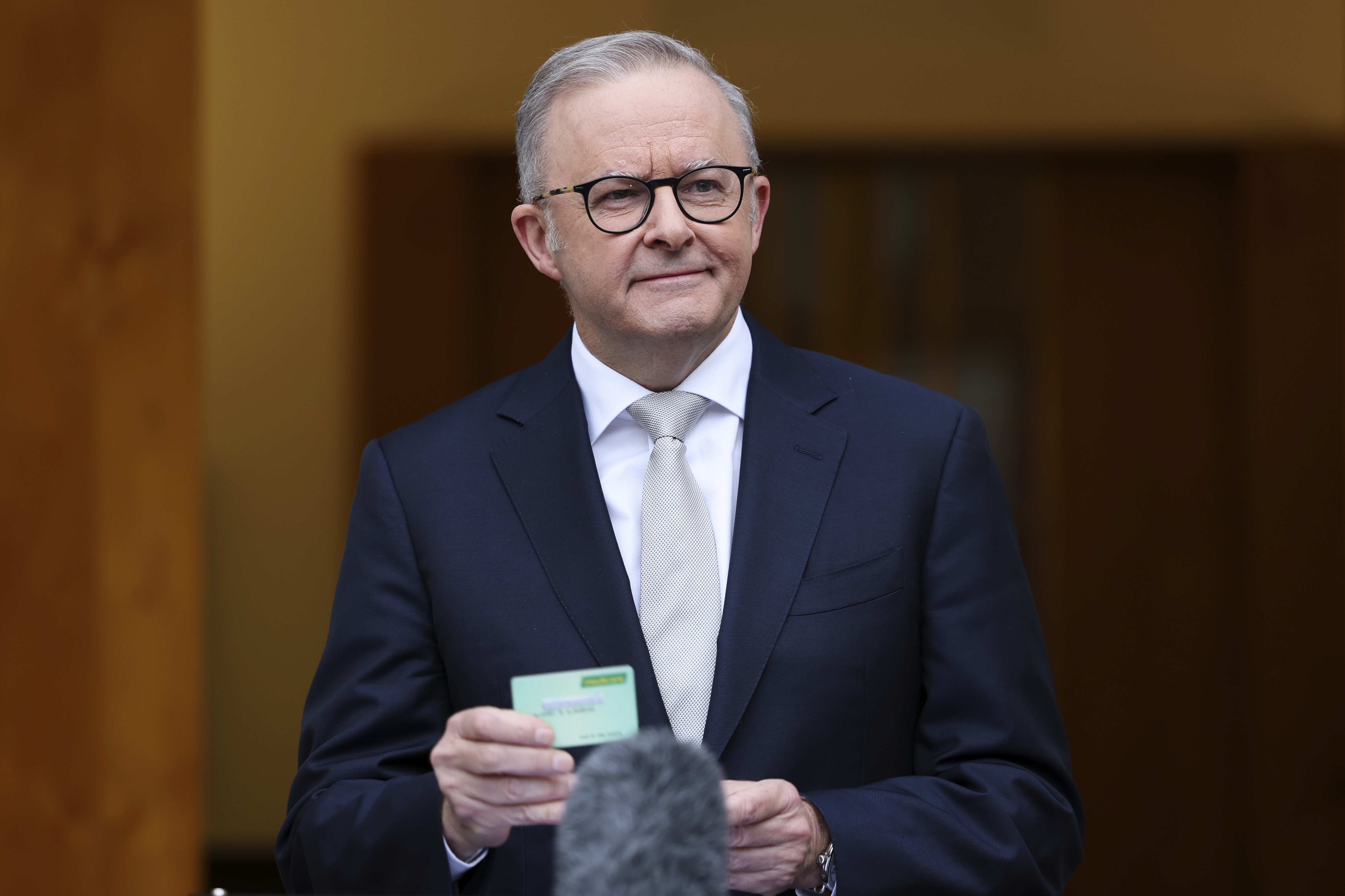 Prime Minister Anthony Albanese holds a medicare card during a press conference after visiting Government House to call for an election, at Parliament House in Canberra on Friday 28 March 202