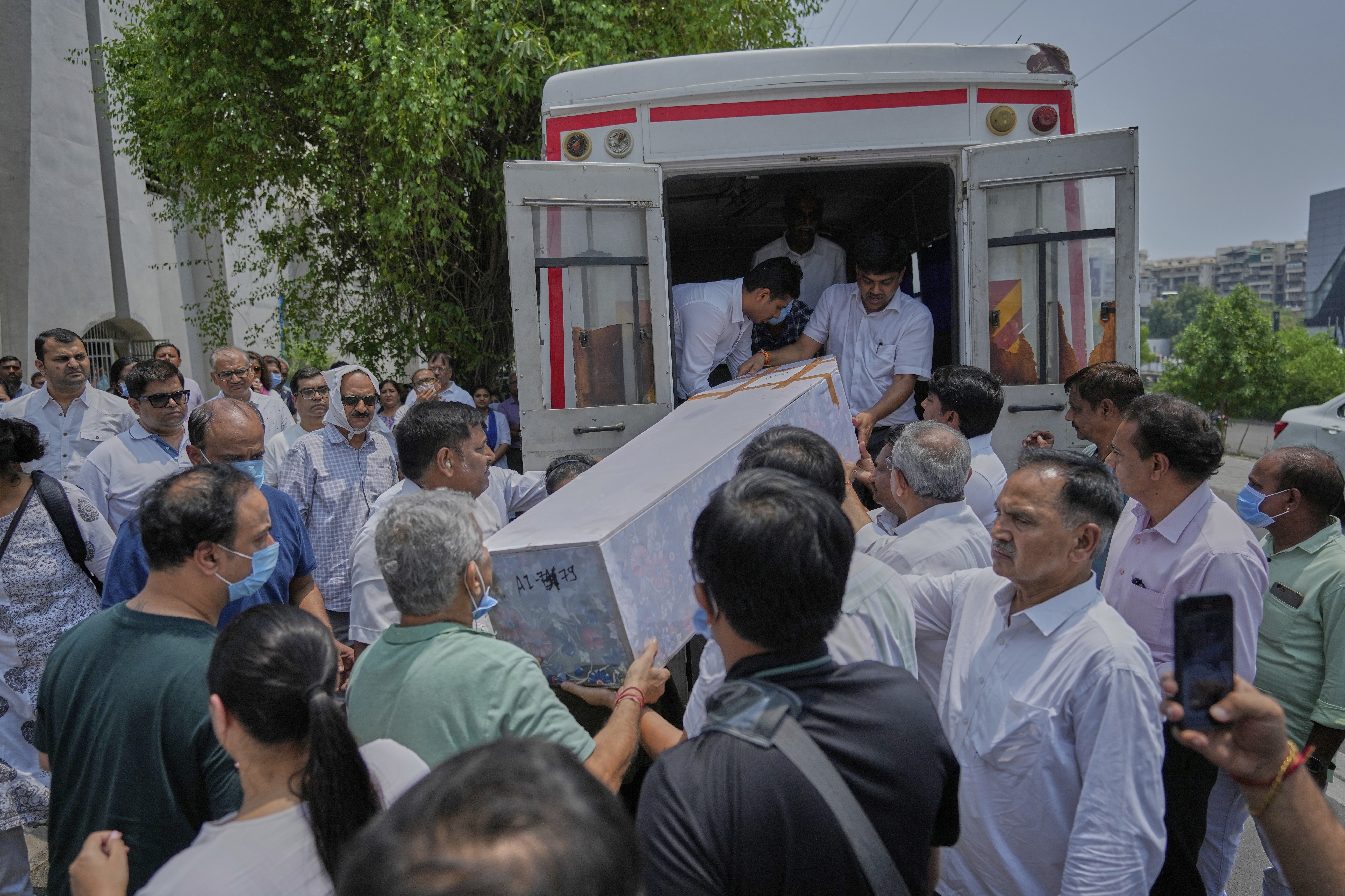Relatives unload the coffin containing the remains of Megha Mehta, a victim of the Air India plane crash, upon arrival at a crematorium during her funeral in Ahmedabad.