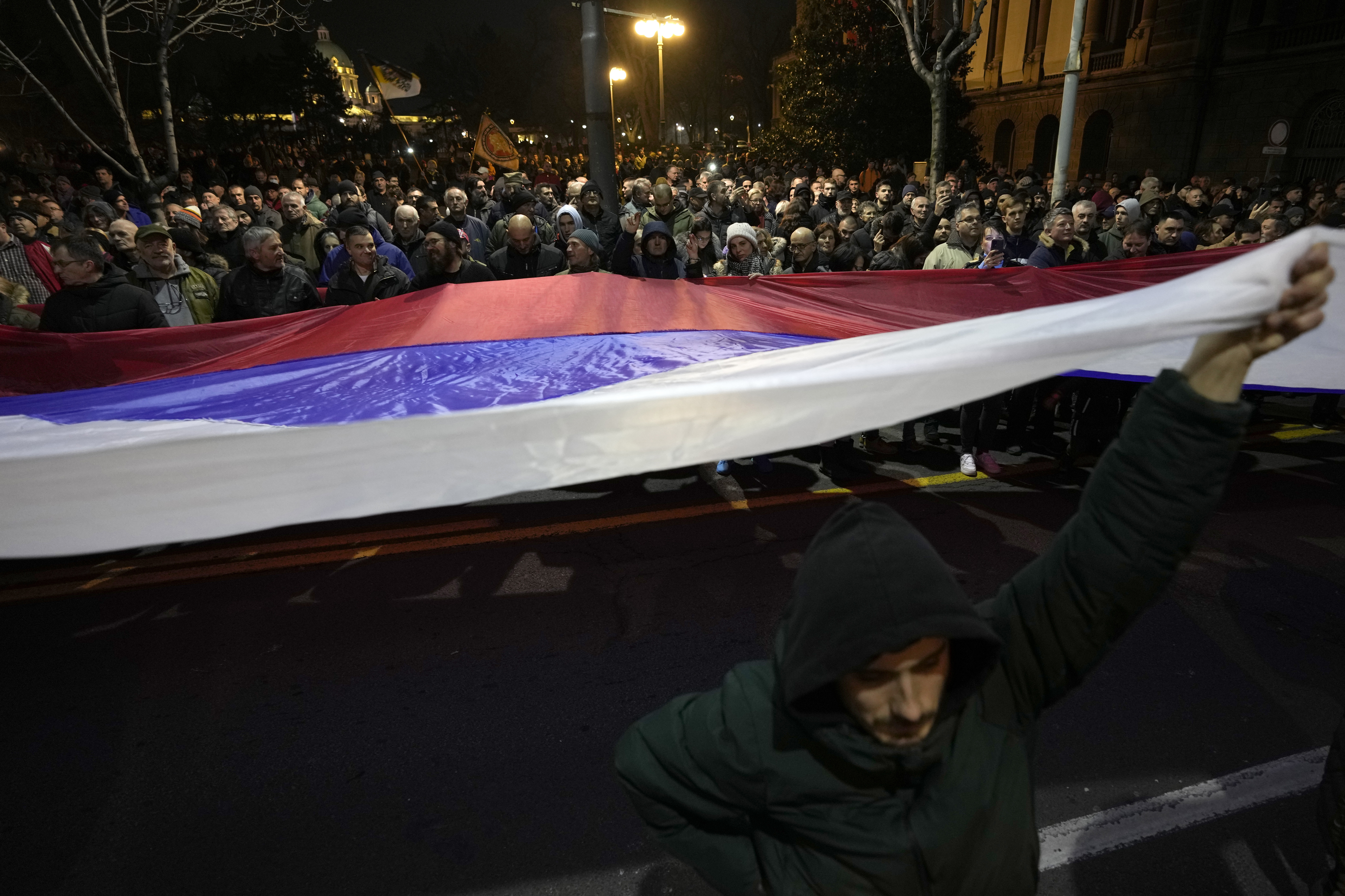 People hold giant Serbian flag during a protest against the Serbian authorities and French-German plan for the resolution of Kosovo, in Belgrade, Serbia, Wednesday, Feb. 15, 2023. Hundreds of pro-Russia nationalists have rallied outside the Serbian presidency building demanding that President Aleksandar Vucic reject a Western plan for normalization of ties with breakaway Kosovo and pull out of negotiations. Shouting Treason and carrying banners reading No surrender, the protesters on Wednesday b