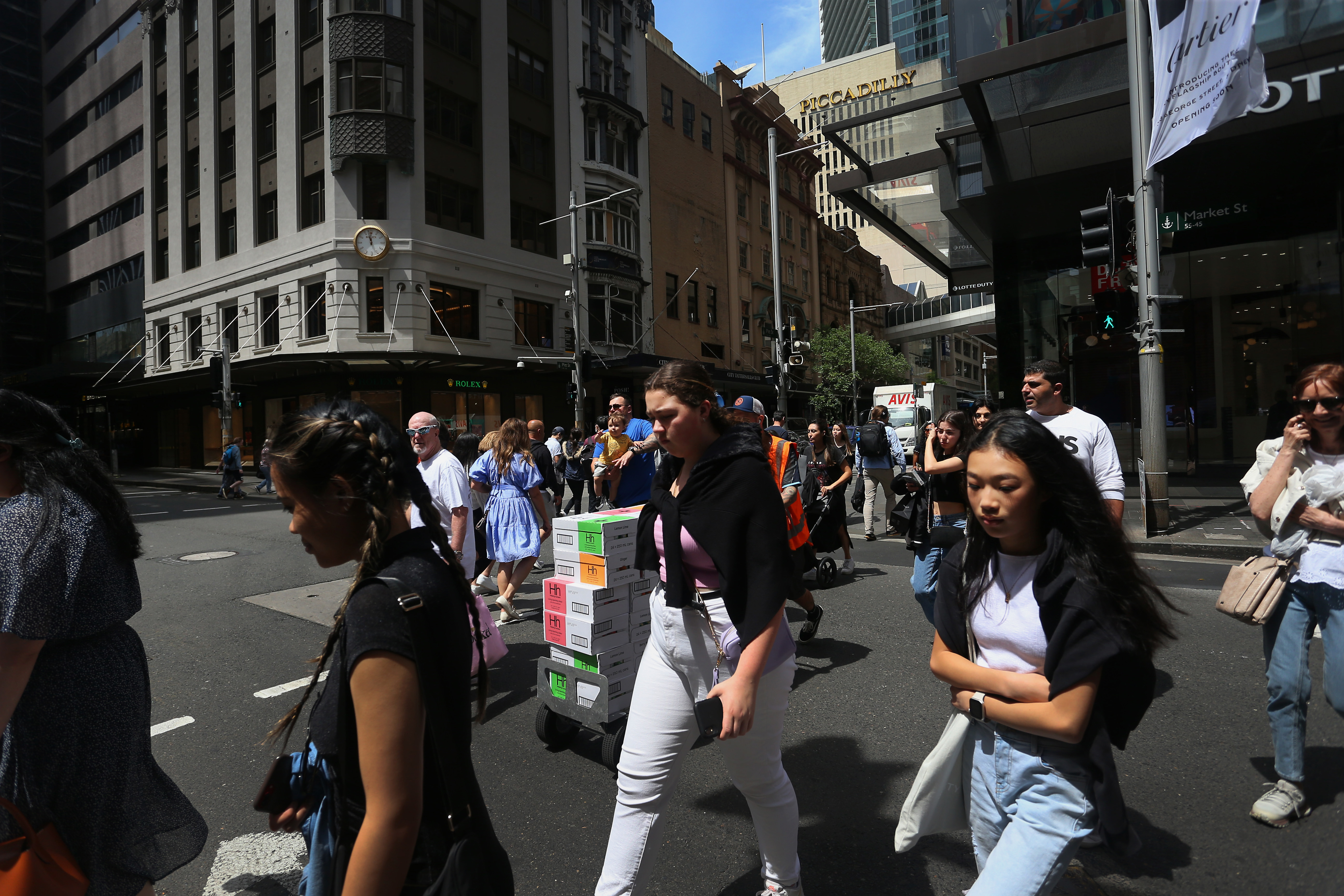 Pedestrians move across Market Street in Sydney, Australia. 