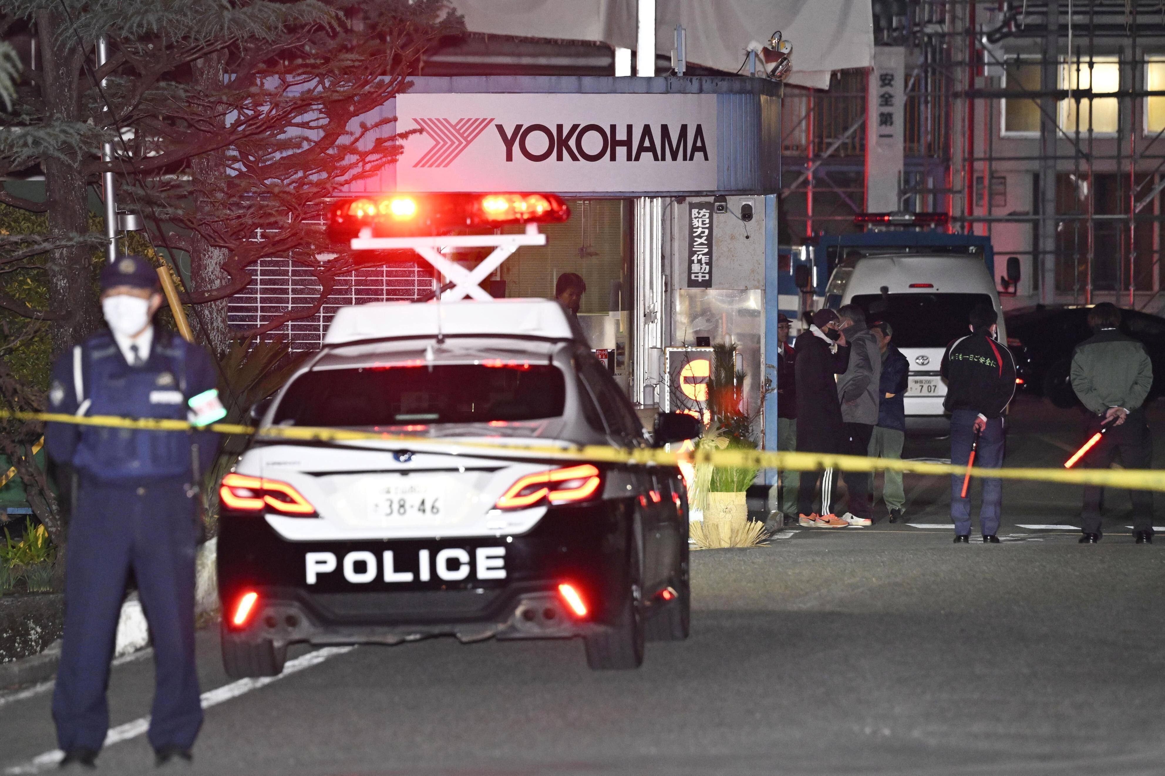 Police officers stand guard at the scene of a stabbing at the Yokohama Rubber Company in Mishima, west of Tokyo.