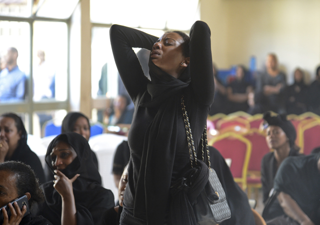 Mourners attend a memorial service held by an association of Ethiopian airline pilots, at which framed photographs of seven crew members were on display, in Addis Ababa, Ethiopia Monday, March 11, 2019. Authorities in Ethiopia, China and Indonesia grounded all Boeing 737 Max 8 aircraft following the crash of an Ethiopian Airlines jetliner that killed 157 people, and investigators found the flight recorders from the field where the plane went down. 