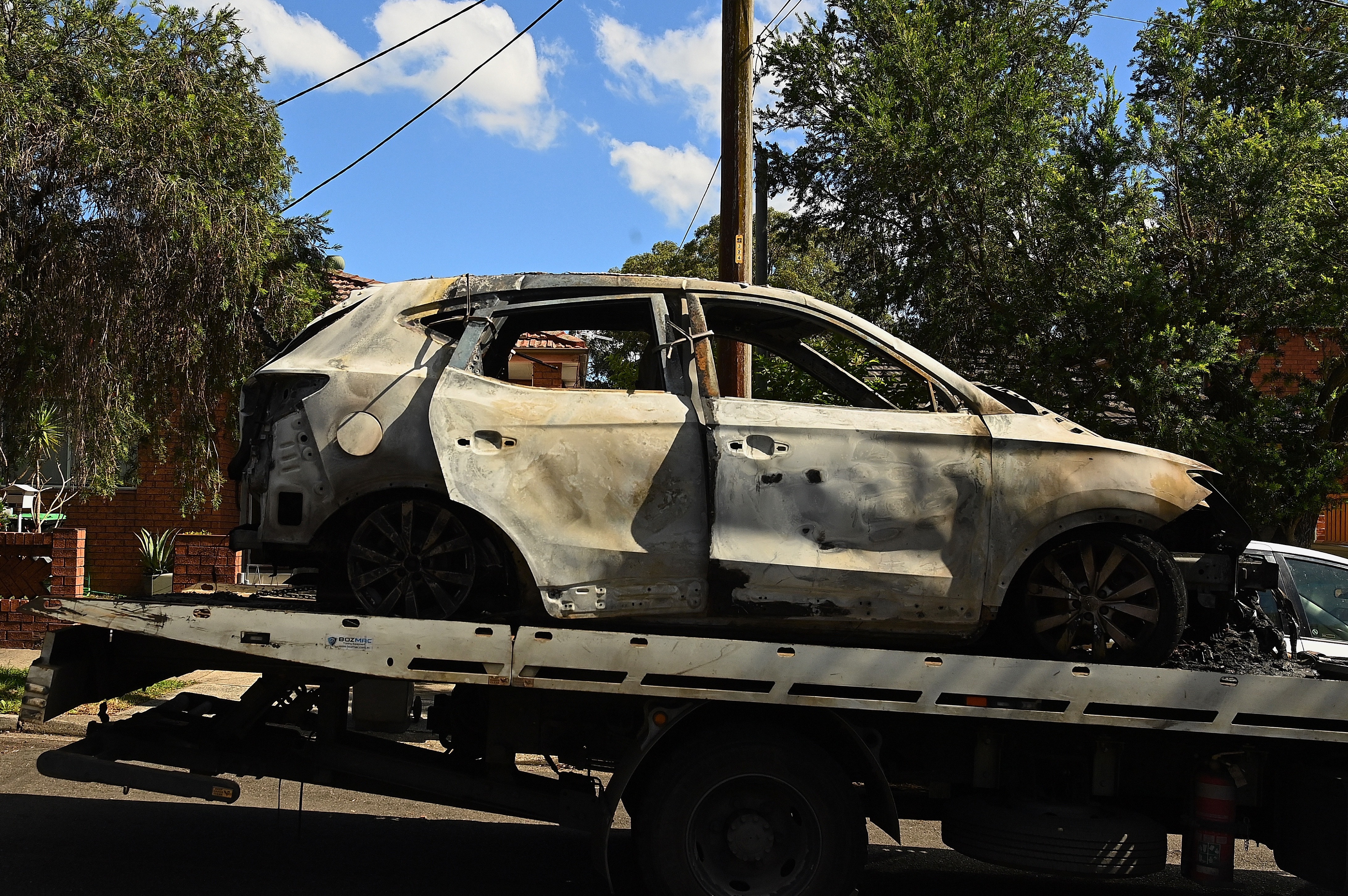 The burnt SUV on Samuel Street in Wiley Park that is connected to the Macquarie Street in Greenacre crime scene where former NRL player Matt Utai has been shot and taken to hospital. Greenacre, NSW. February 17, 2026. Photo: Kate Geraghty